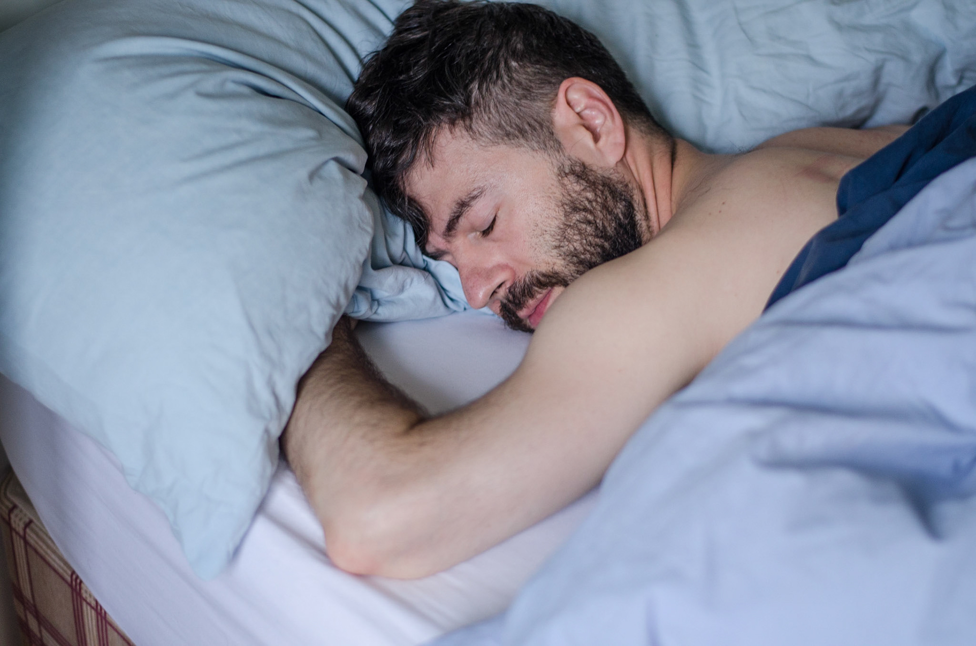 Bearded man sleeps under sheets. Homen dorme debaixo das cobertas. Male nudity, nude, man, portrait, hairy, beard, naked. Nudez masculina, homem, pelado, barba, peludo, retrato, nu.