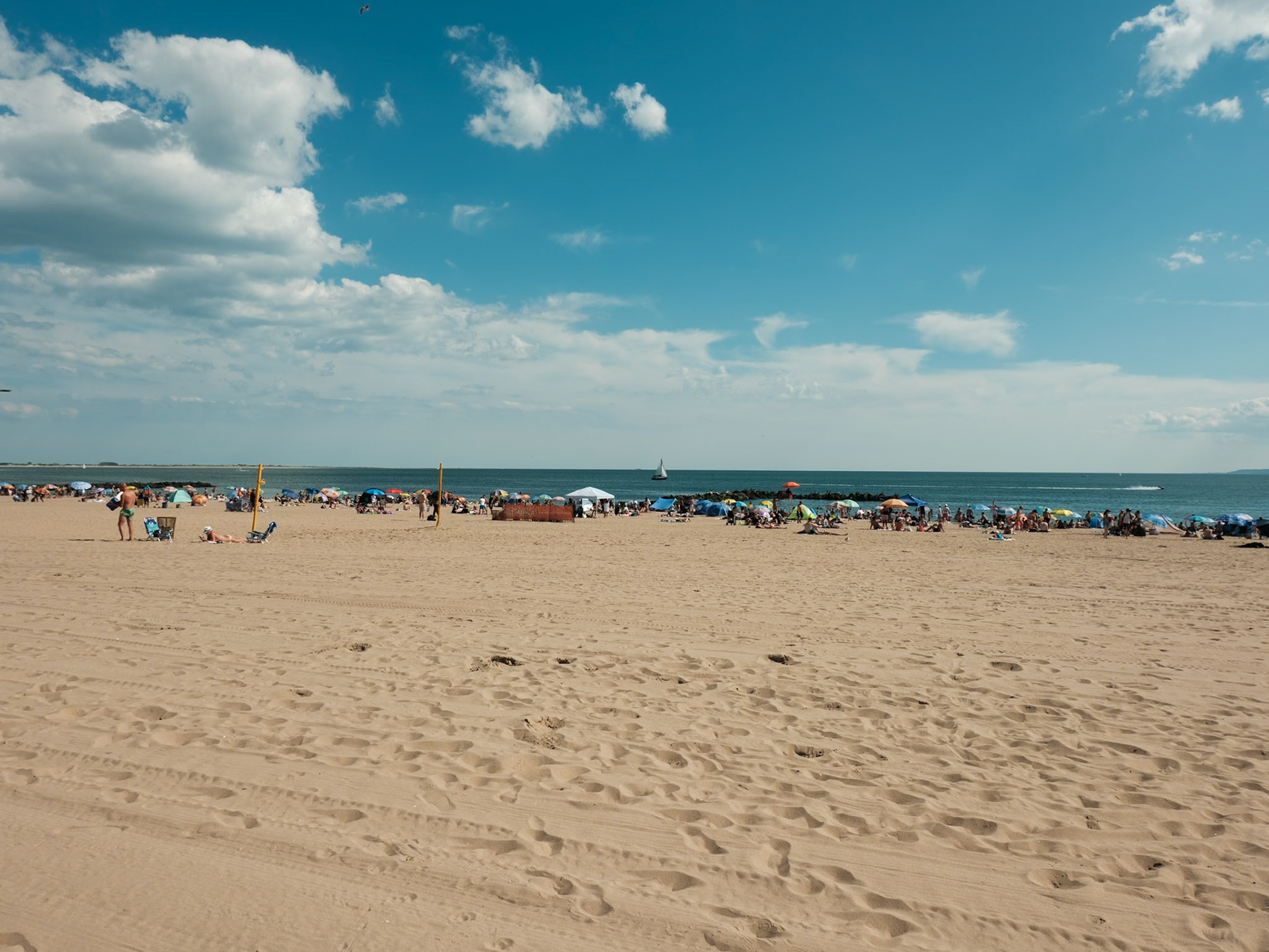 Beach Crowd on Coney Island with Sail Boat in Background September 2024