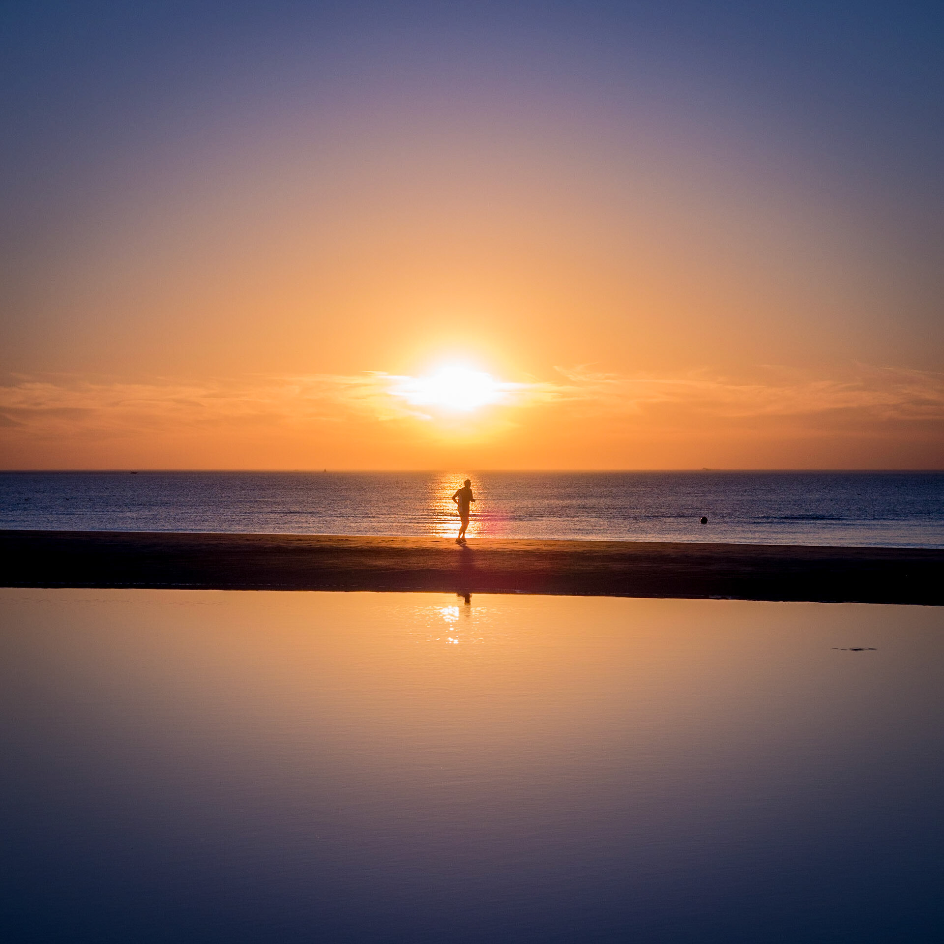 Läufer bei Sonnenuntergang am Strand