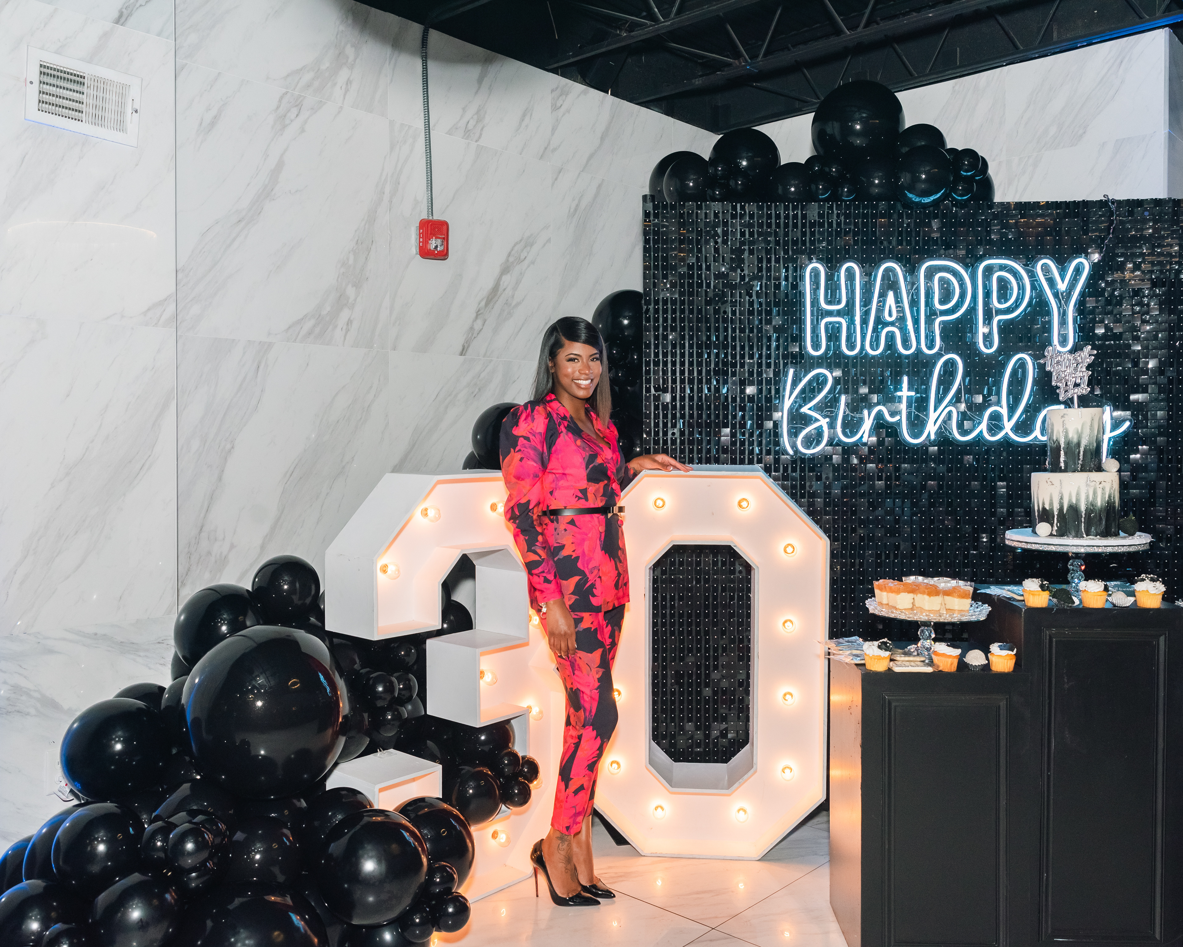 Event photo capturing a birthday celebration moment with balloons and signage