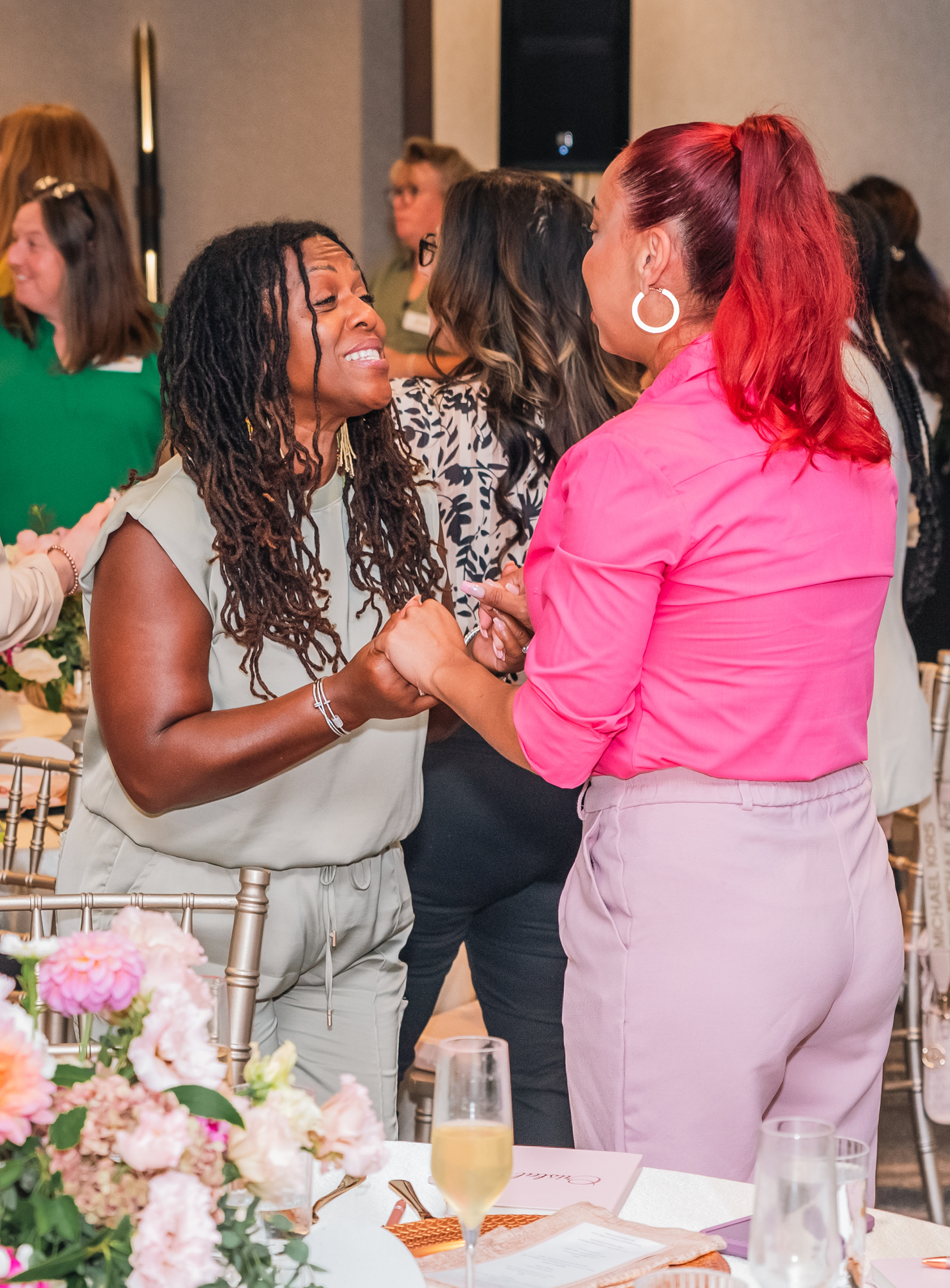 Candid event image of attendees greeting one another during a networking moment.