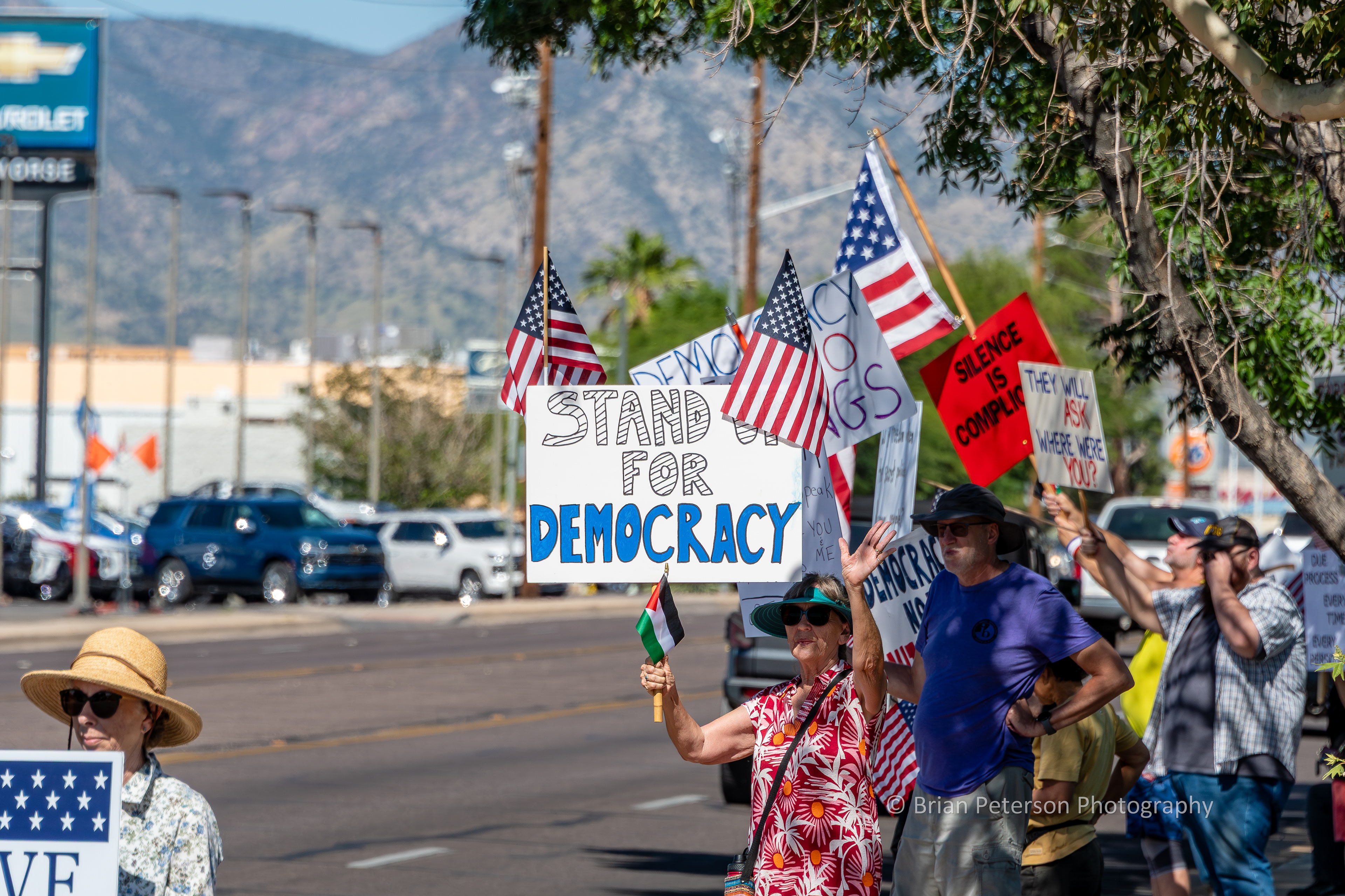 The protesters are standing along Fry Blvd. in front of Veterans Memorial Park.
