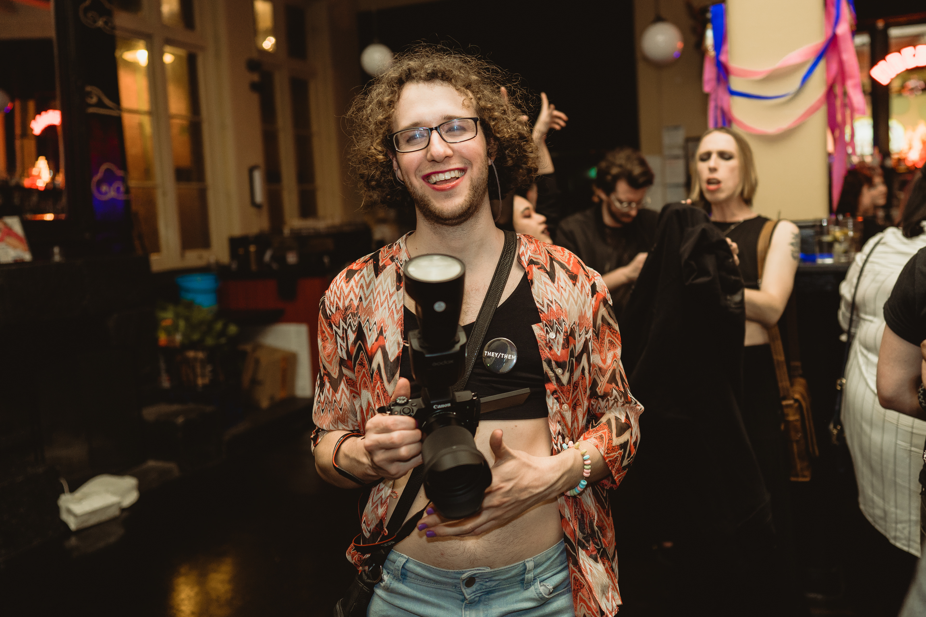 Millie Gryphon, a photographer with a camera in their hands at BONEZ Alternative Queer Party