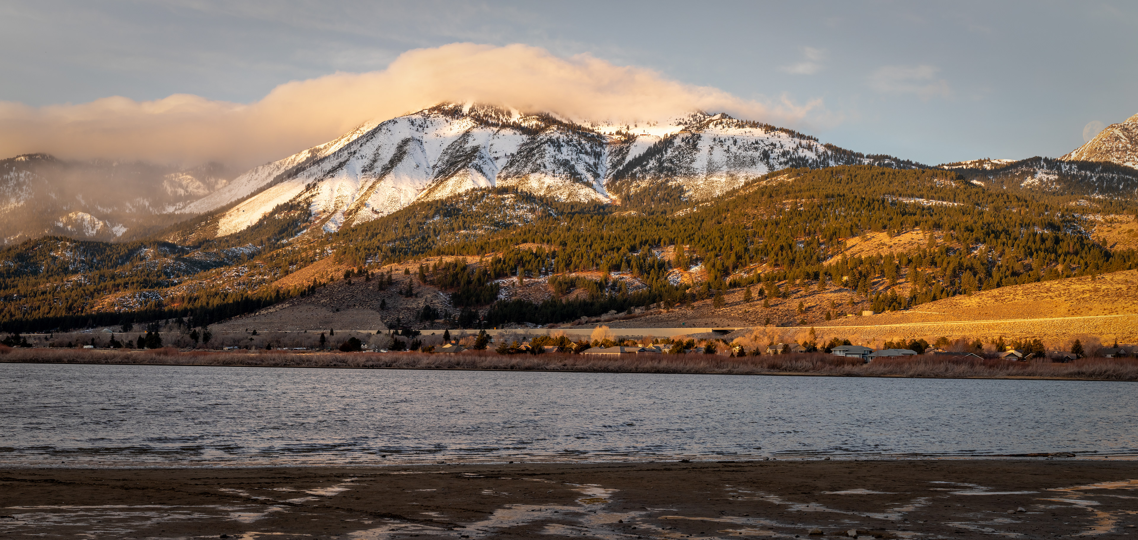 Slide Mountain with cloud cover, and Washoe Lake in the foreground, and the moon setting.