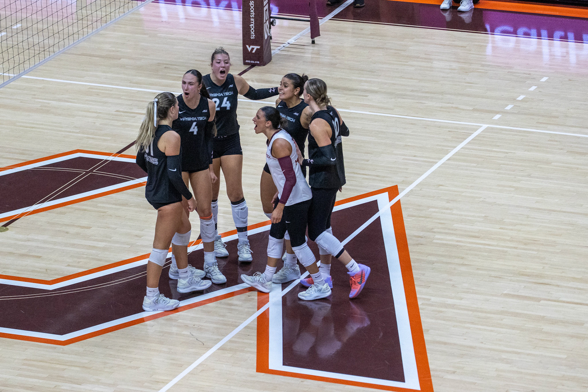 The Hokies celebrate after winning a rally, ready to carry their momentum into the next point