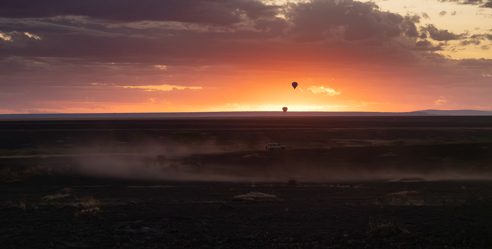 Sunrise, balloons, dust and vehicle