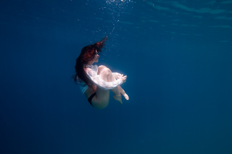 Eleftheria Bargiota floating underwater in a curled pose with flowing hair, created for the “Treis Epoxes” album cover.