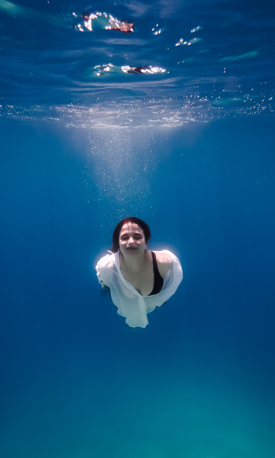 Eleftheria Bargiota swimming just below the sunlit water surface, created for the “Treis Epoxes” album visuals.