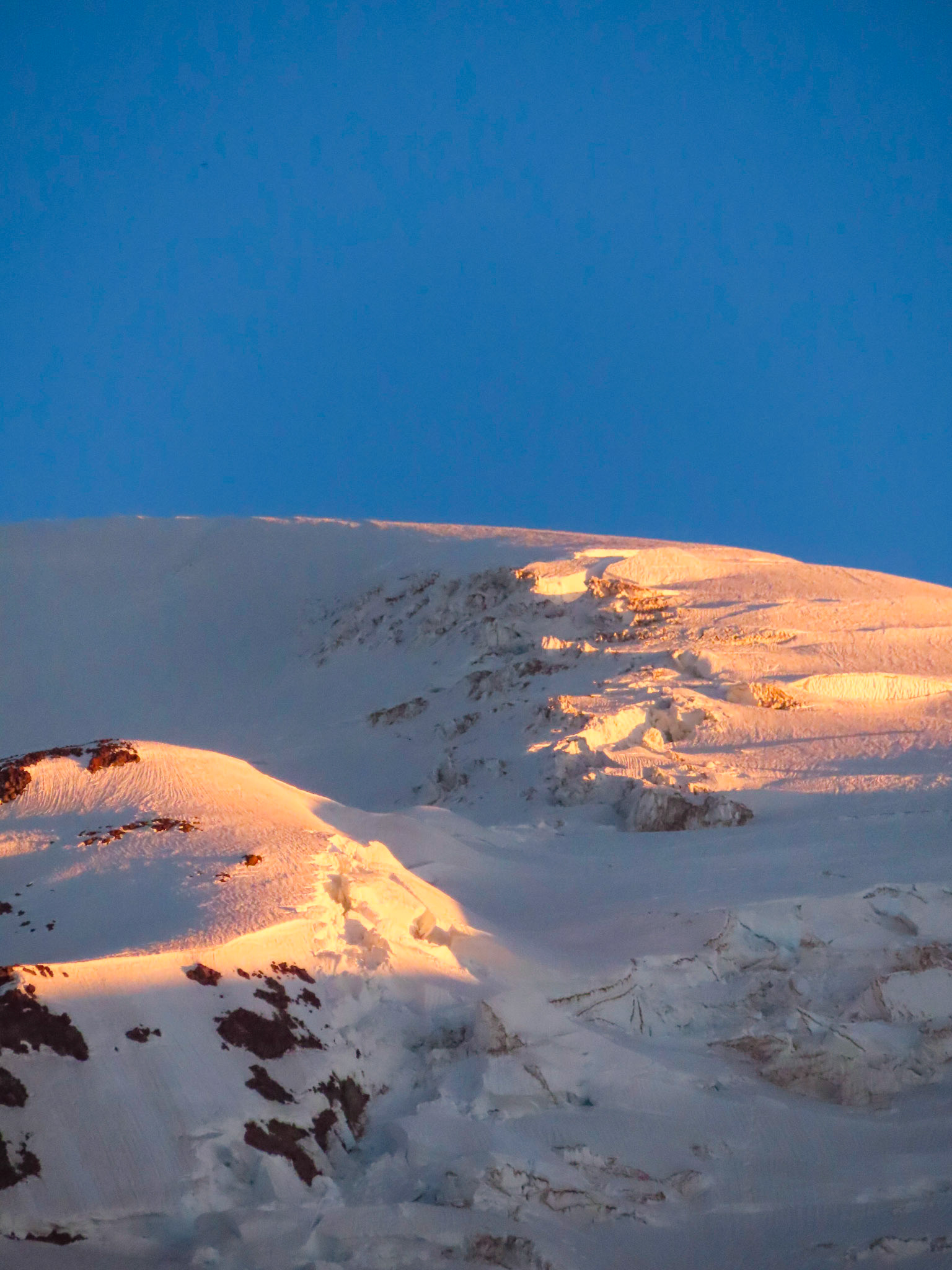 First light illuminates the seracs and cornices between 13,000 and 14,000 feet on Mt Rainier. Wilson Glacier headwall (left) and upper Nisqually Glacier (right).