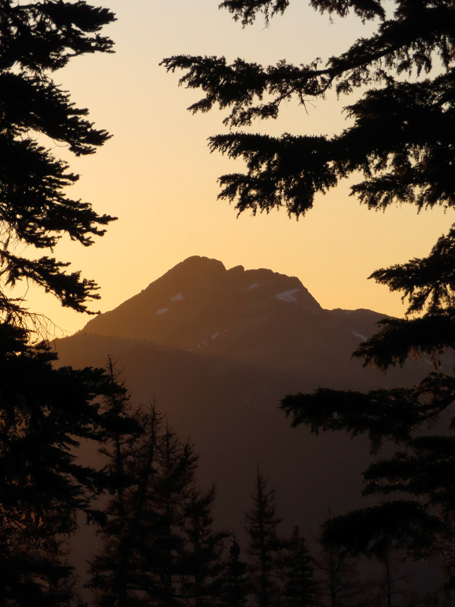 Sunset rays bounce off of the Bismarck Peak within the Rattlesnake Peaks range.