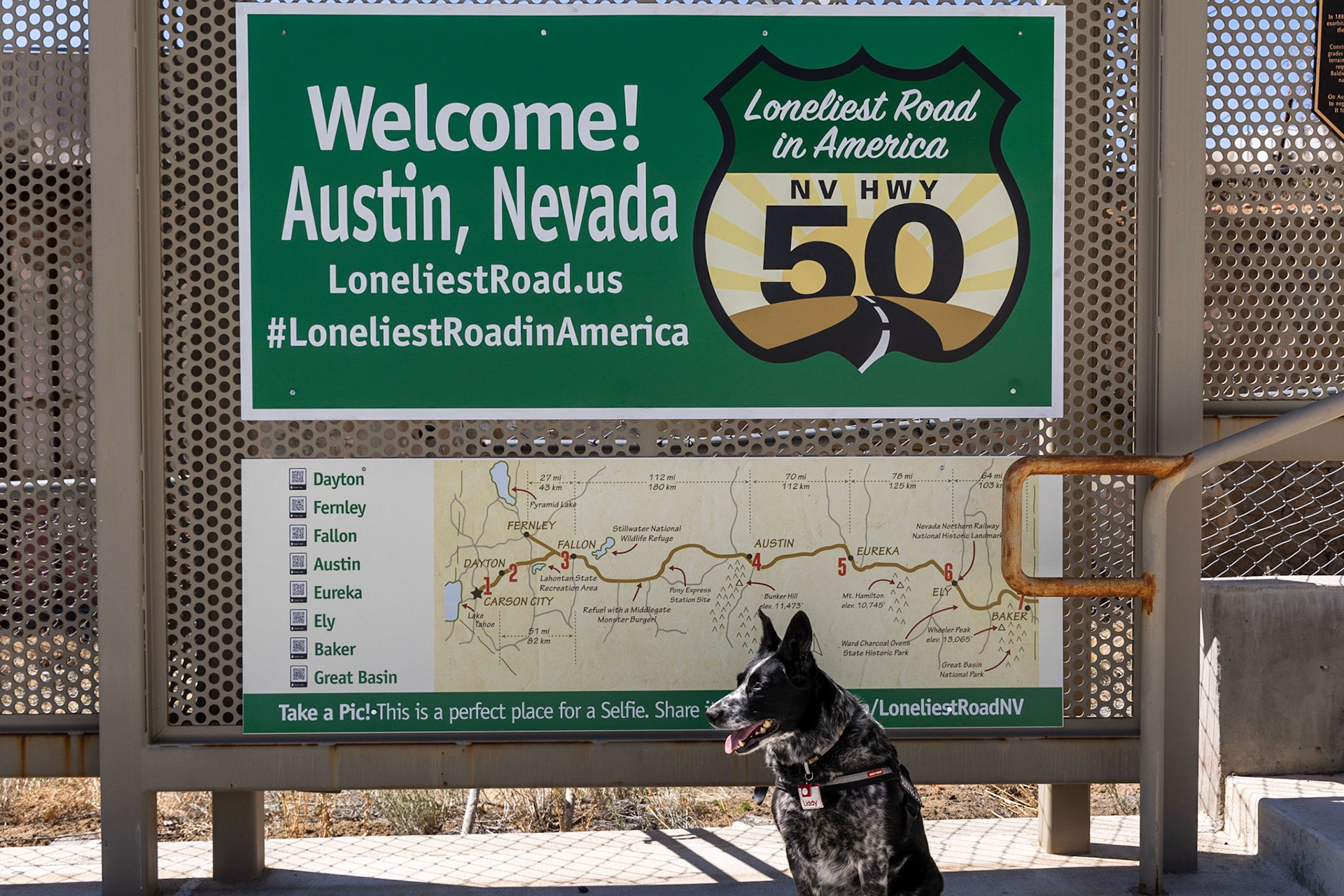 This sign behind Liddy proclaims US 50 to be the Loneliest Road in America.