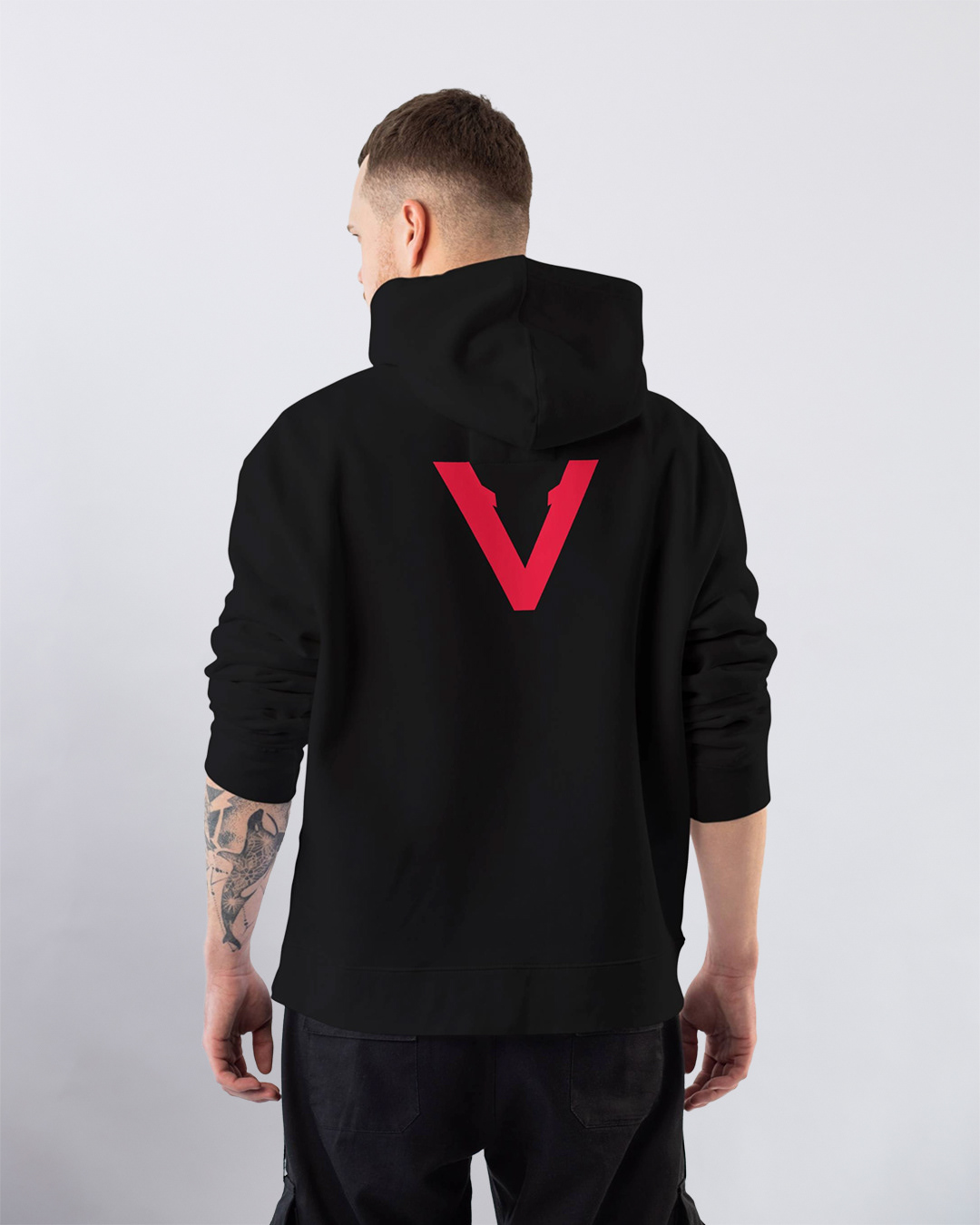 Back view of black Vinciani hoodie featuring bold red V-Mark centered on the upper back, worn by model against a minimal white background - Vinciani Code Red collection.