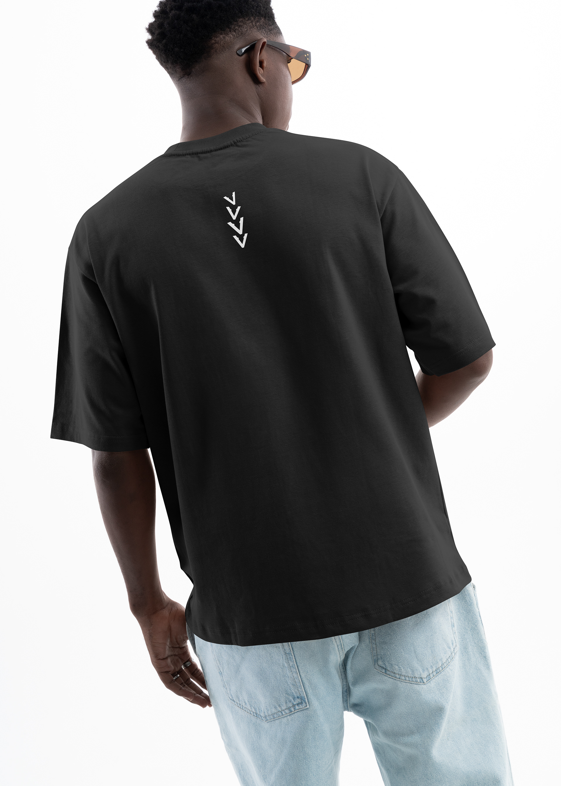 Rear view of a model wearing the Vinciani Ascension Stripe oversized black T-shirt featuring the signature white Ascension Stripe graphic centred below the neckline, showcasing premium minimalist luxury streetwear design.