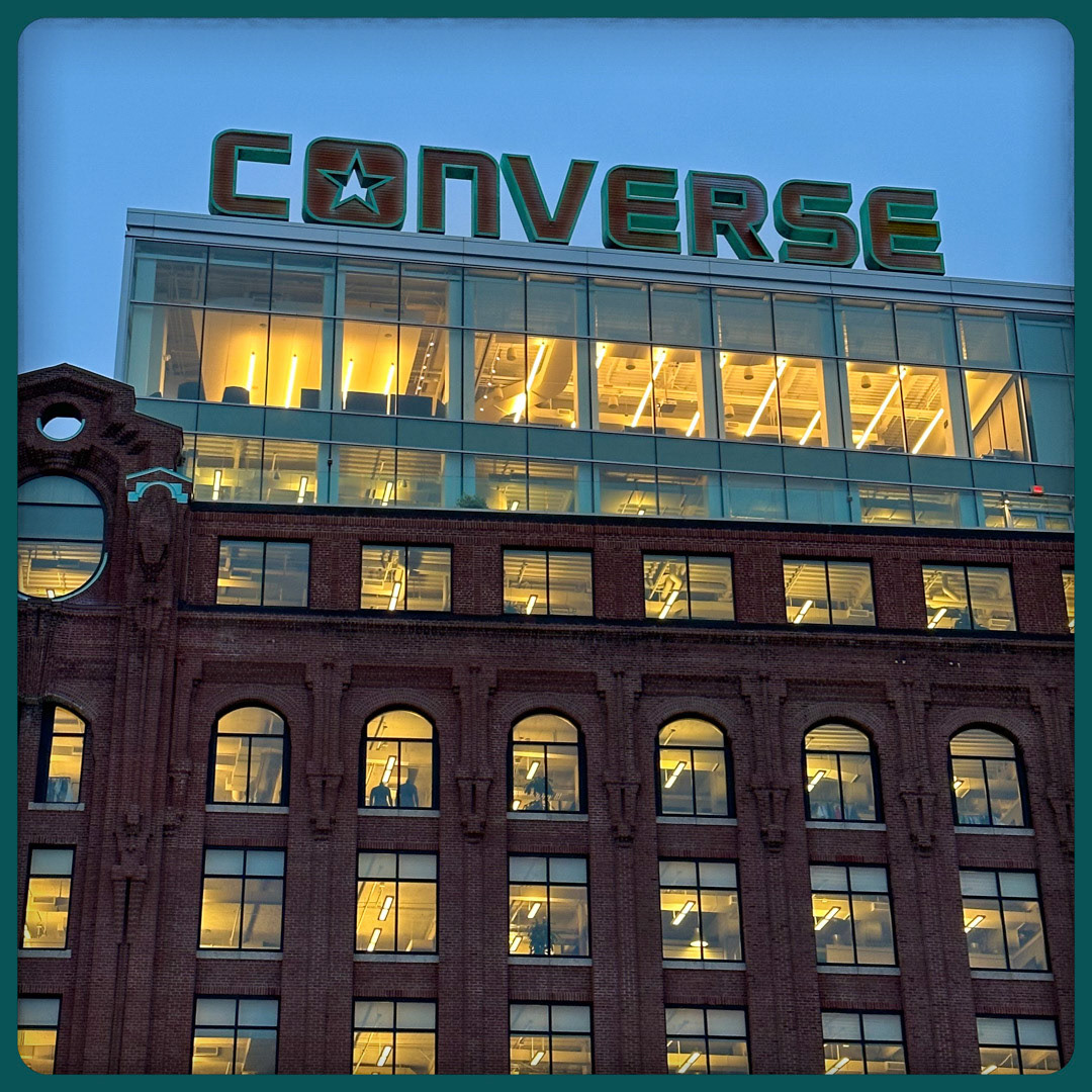 99. Converse Headquarters Sign •••  In 2015, when Converse relocated its headquarters from the suburbs to a century-old restored property in Boston’s Lovejoy Wharf, they wanted to make a statement with their signage. Installed on the roof of the 9-story building is one of the most impressive signs in the city. Extending 10-feet tall and spanning 80-feet wide, the letters were designed to match the building’s rust brick facade and copper patina trimmings. (#99 of 100 in the Boston Signage Project)