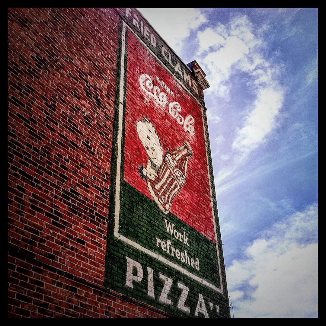 60. Coca Cola Fried Clams and Pizza Sign ••• This classic Coke sign in Somerville is in remarkably good condition, despite the fact that no business in this building has served fried clams or pizza for years. It looks like a typical hand-painted ad, until you realize that the kid holding the bottle is really a creepy little dude who belongs in a Tim Burton movie. (#60 of 100 in the Boston Signage Project)