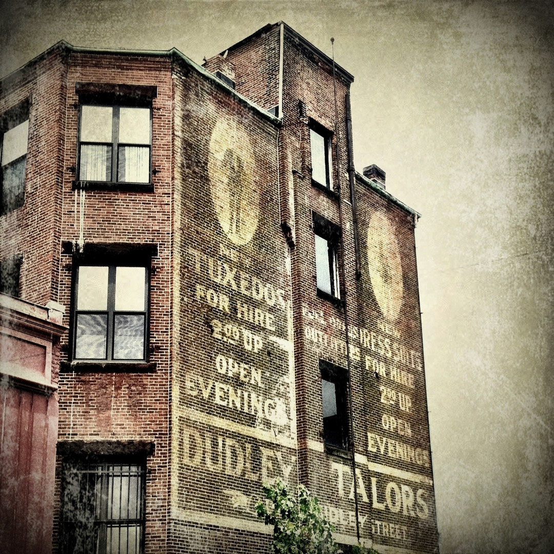 55. Dudley Tailors Ghost Sign ••• Back in the day if you were looking for a tuxedo or pressed suit for less than three bucks, Dudley Tailors would take care of you. This ancient ghost sign is located on the back of an old building on Washington Street in downtown Roxbury and can be seen from the Dudley Bus Station. (#55 of 100 in the Boston Signage Project) ••• 2023 Update: Building may have been razed.