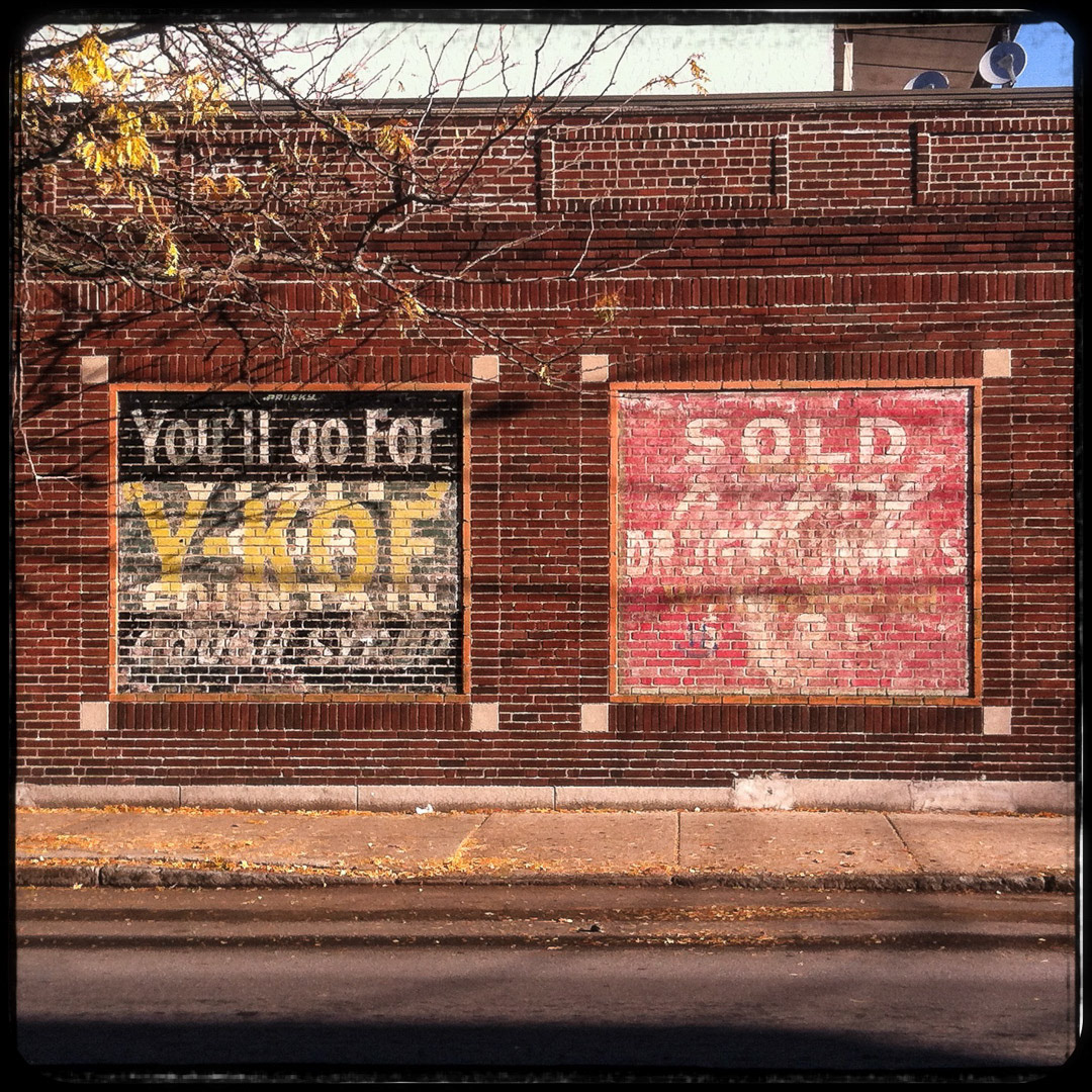 88. Chelsea Double Ghost Signs ••• On the corner of Central Ave and Shurtleff Street in Chelsea is this set of bizarre double ghost signs. Each square has 2 ads from different time periods overlaying each other. On the left is "You'll go for Y-KOF cough syrup" combined with "Visit our Fountain". On the right is "Sold Drug Counters" covering an old Coca-Cola ad. (#88 of 100 in the Boston Signage Project)