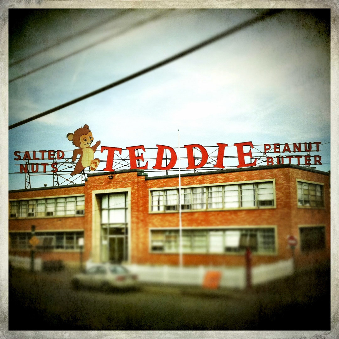 56. Teddie Peanut Butter Sign ••• Not far from the Mystic River in Everett is the family-owned Leavitt Corp, the makers of the number one selling natural peanut butter in the northeast. Their classic facility sign, erected at some point in the 1960s, sports a cute running bear (chipmunk?), and is lit at night with floodlights since it no longer illuminates on its own. (#56 of 100 in the Boston Signage Project)