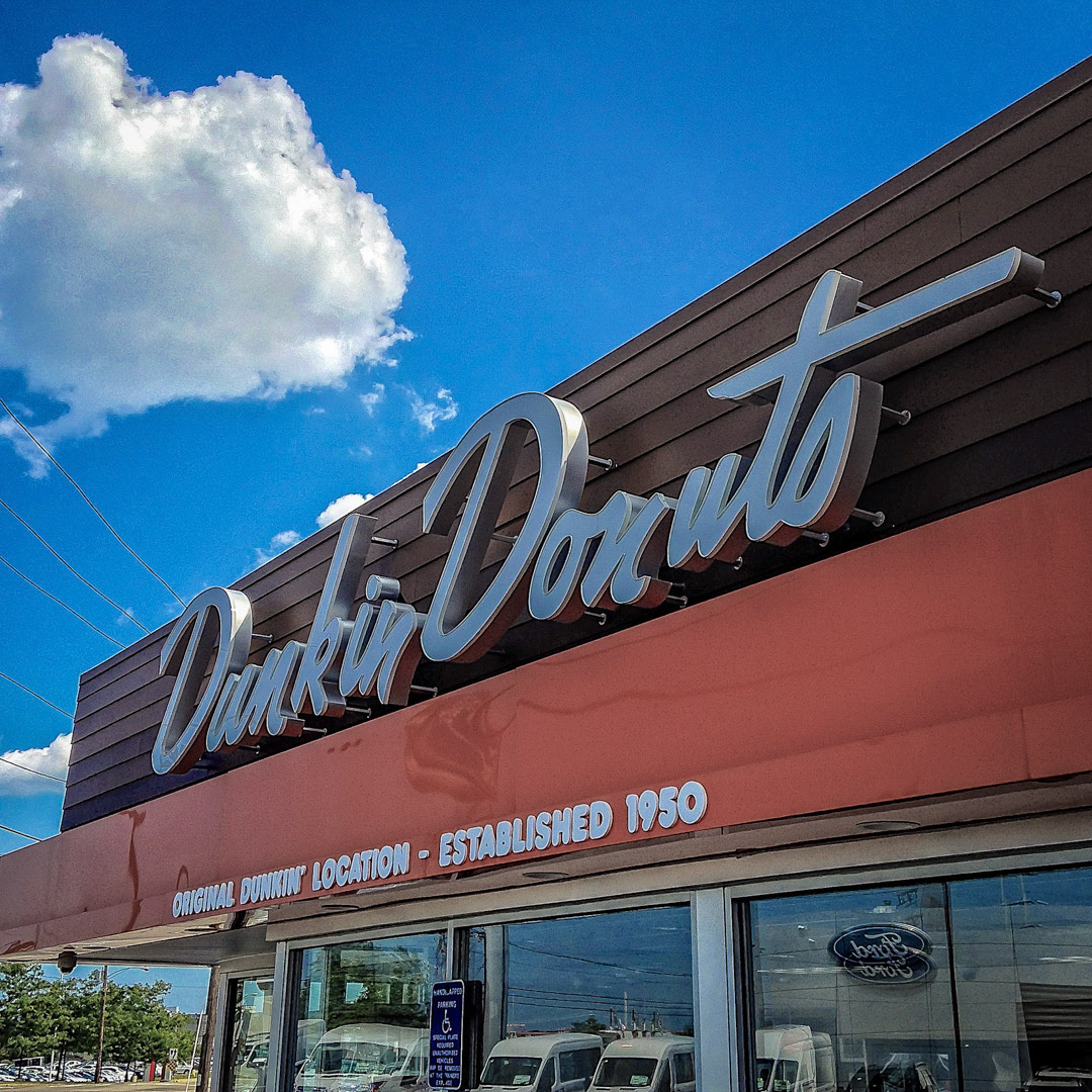 93. Original Dunkin Donuts Sign ••• Here on the on Southern Artery in Quincy is the very first Dunkin’ Donuts. Back when it opened in 1950, coffee was sold for a dime and a script sign of the original logo was displayed over the door. In subsequent years the store went through several renovations, lost its uniqueness, and looked like all the other DD's out there. But in 2011, the shop went back to its roots and did a retro-renovation and replicated the original sign. (#93 of 100 in the Boston Signage Project)