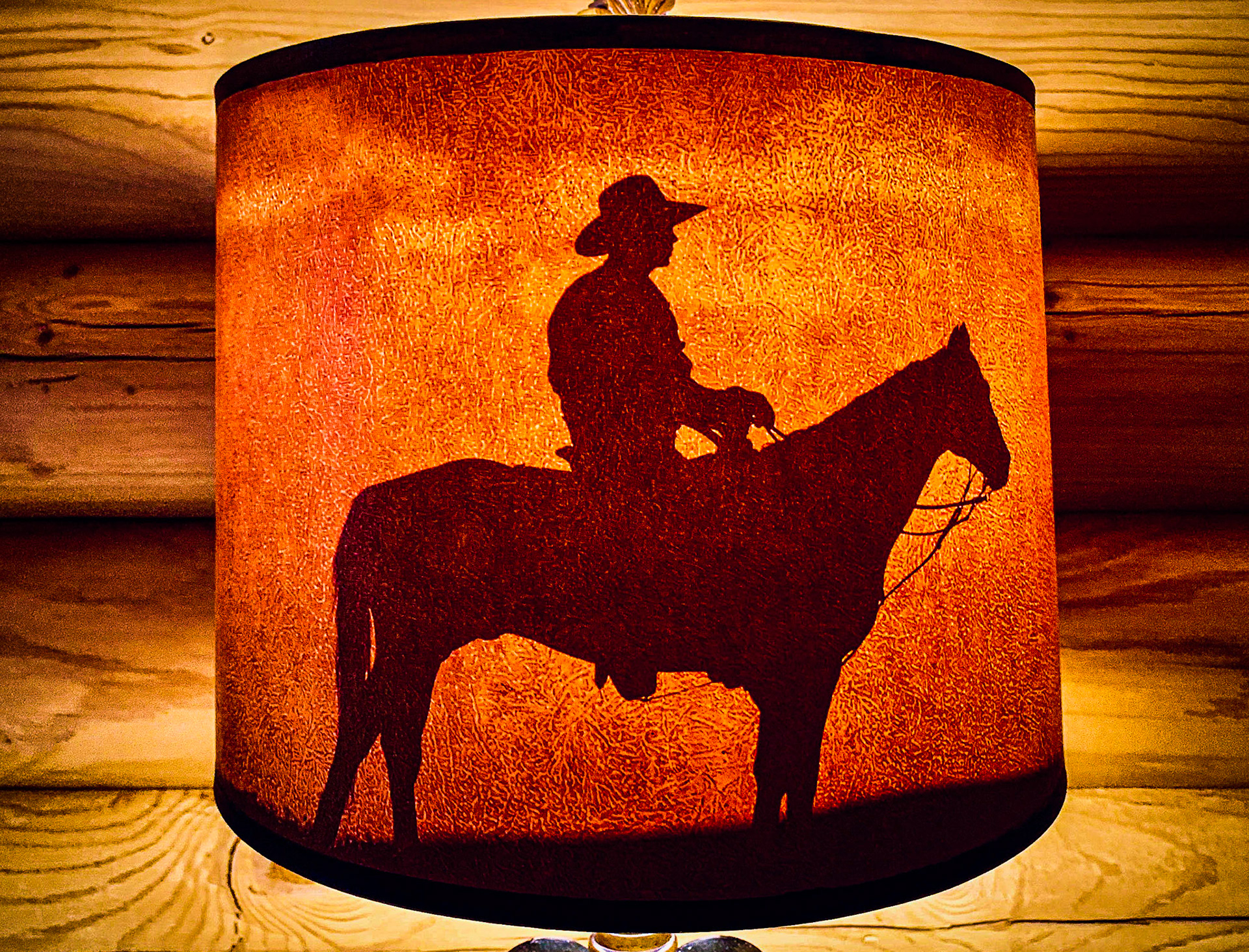 July 24, 2019Cowboy silhouette lampshade in a log cabin at the Cody Cowboy Village in Cody, WY.Watch out for the feral rabbits!