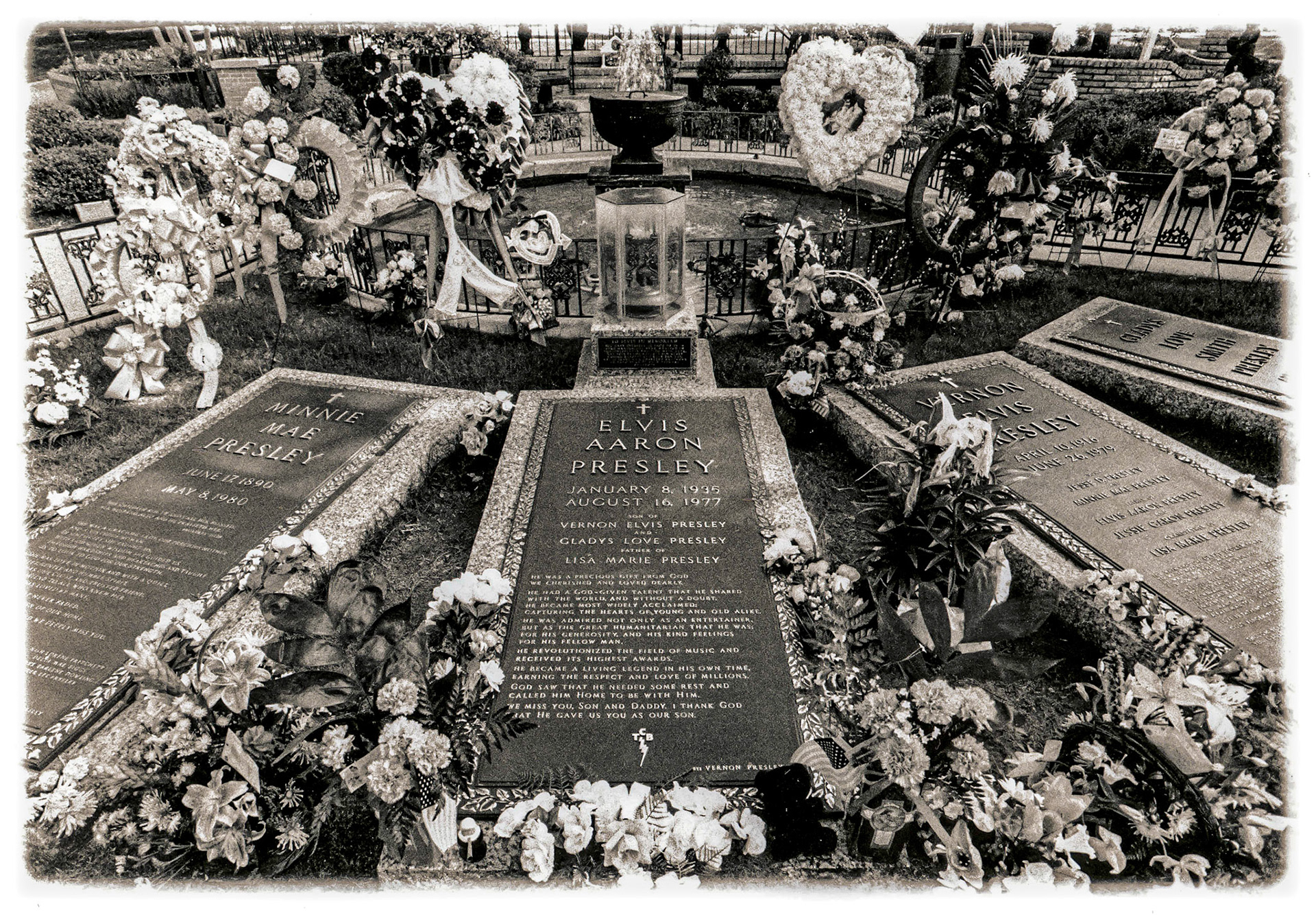 July 31, 2019Elvis is dead...Image shot of Elvis Presley's grave in the Meditation Garden at Graceland Mansion in Memphis, Tennessee. The flowers at the grave are an average accumulation left daily by visitors. Just before I shot this, a lady had knelt down and left some flowers, paused and walked away. The guard said she showed up with flowers nearly every day he's worked there...I chose not to invade her privacy by photographing her.