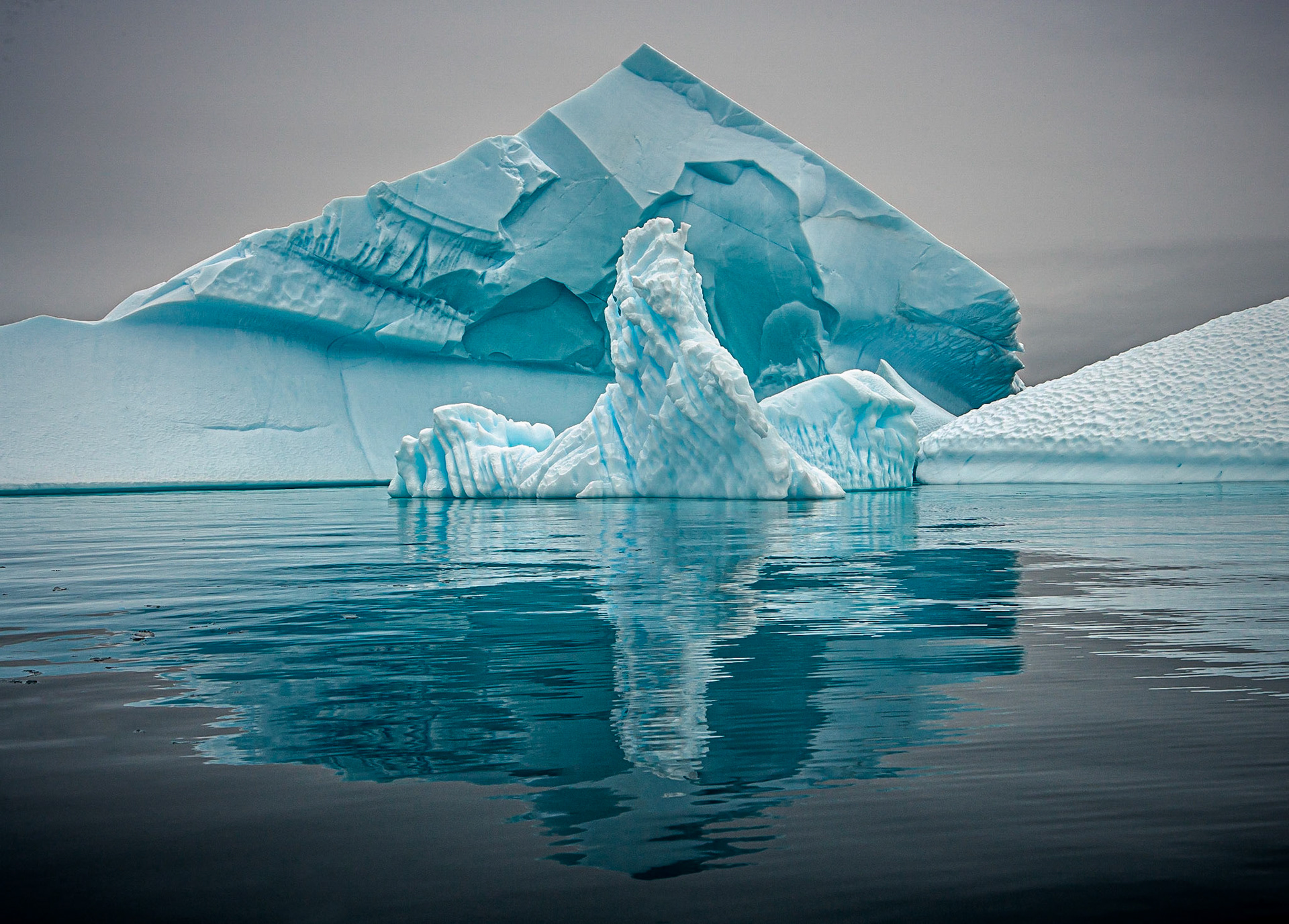 January 21, 2020Icebergs collected together in the "Iceberg Graveyard" in Pleneau Bay in the Antarctic Peninsula. The bay is near the Lemaire Channel and Petermann Island and traps iceberg that come into the bay but can't get out. They end their lives there...but unlike other areas where the icebergs are free roaming and floating which makes them dangerous to approach, the icebergs in the Graveyard are often grounded on land–which makes them safer to approach, so close you can touch them!