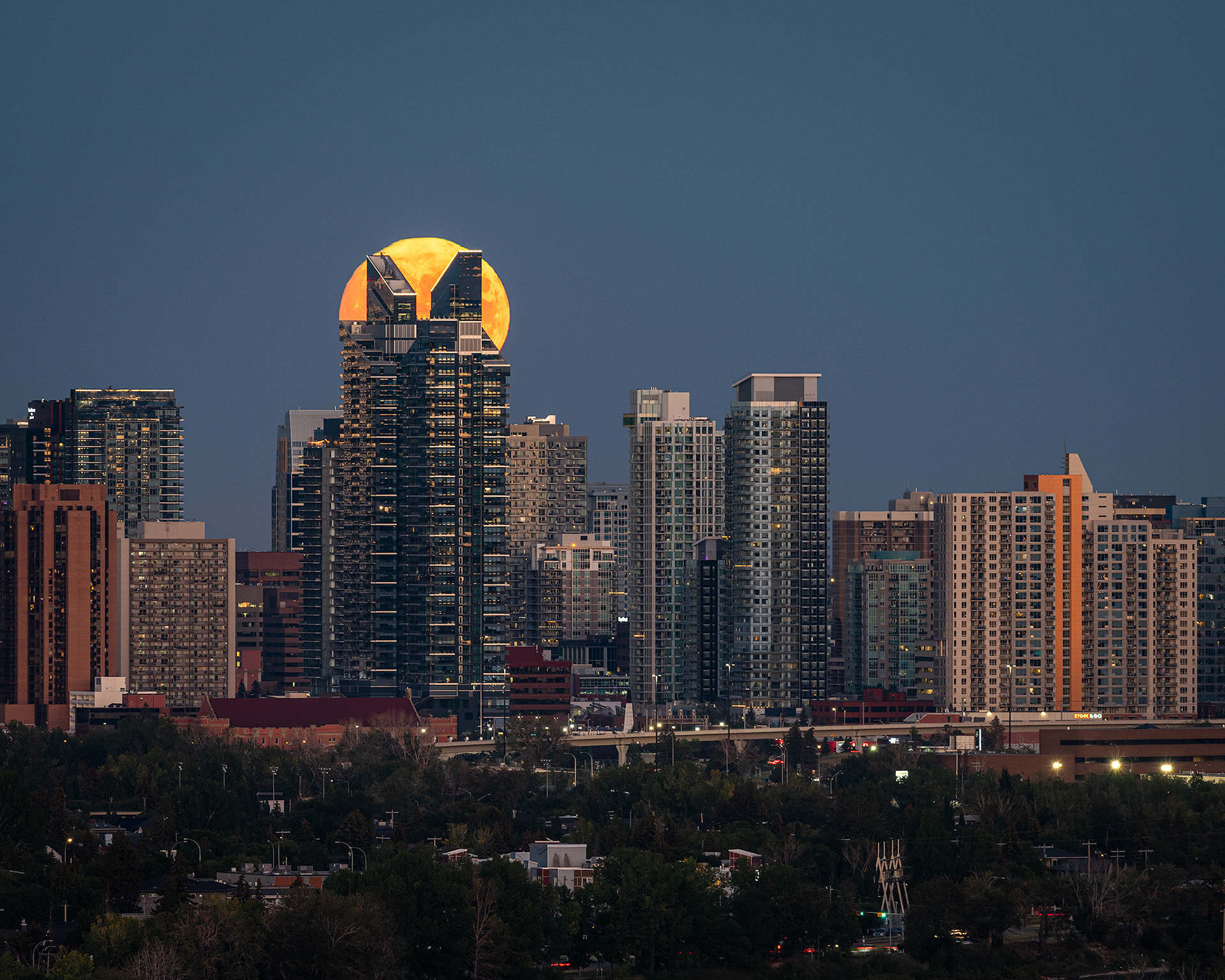 5x4 Cityscape of the Downtown West End Calgary skyline with the Harvest Moon aligned at the top of the West Village Towers, from Edworthy Park, Calgary, AB