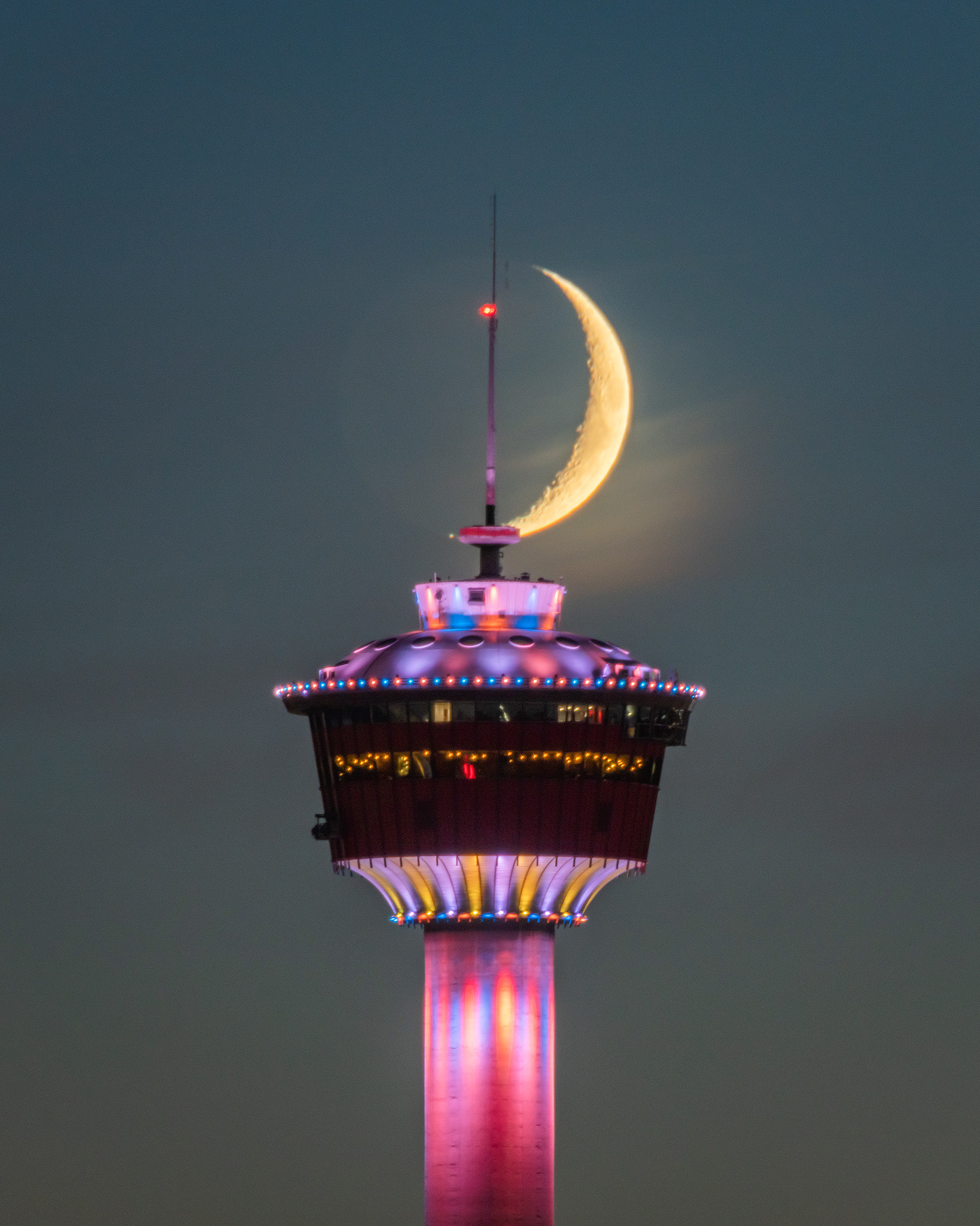 Setting Waxing Crescent Moon (14.5%) aligned with the Calgary Tower, from Tom Campbell's Hill Natural Park, Calgary, AB