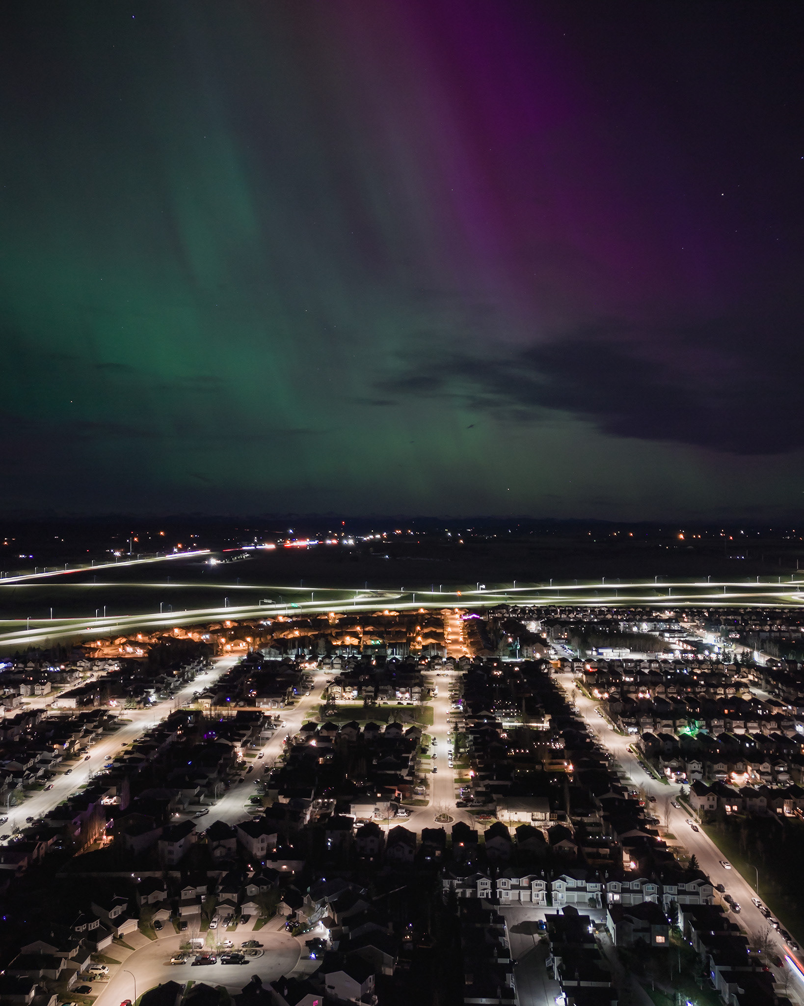 Photo of an Aurora occurrence, with neighborhood city lights in the foreground, from Bridlewood, Calgary, AB - May 11th