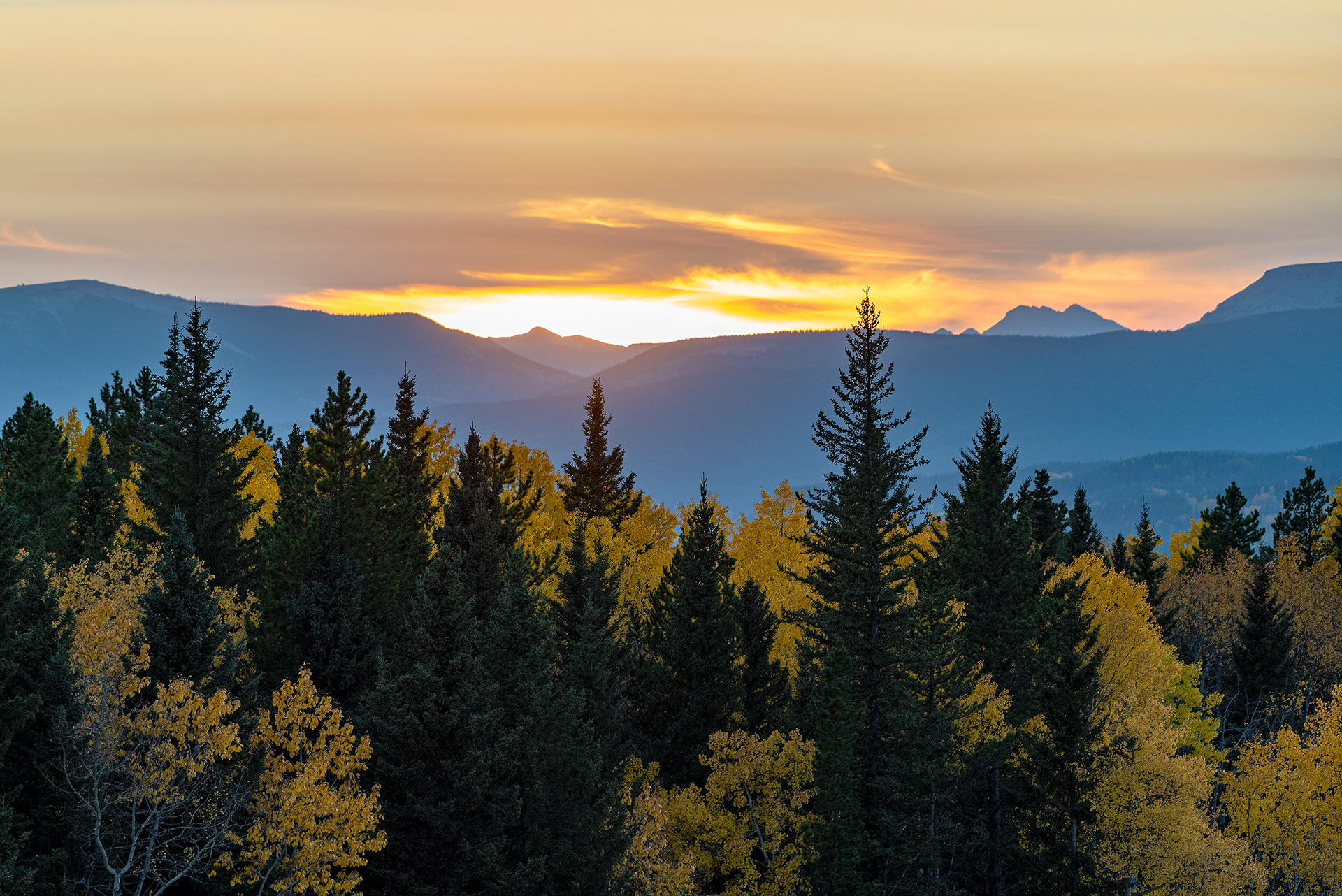 Foothills and mountains in a somewhat smoky haze at sunset in Foothills County