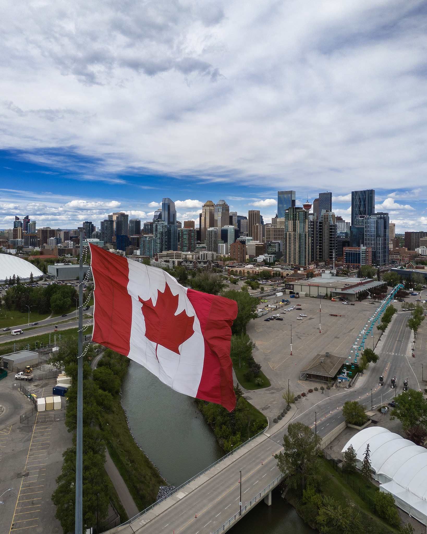 Photo of a Canada flag, with the Downtown Calgary skyline in the background, from near the Calgary Stampede, Calgary, AB - May 29th