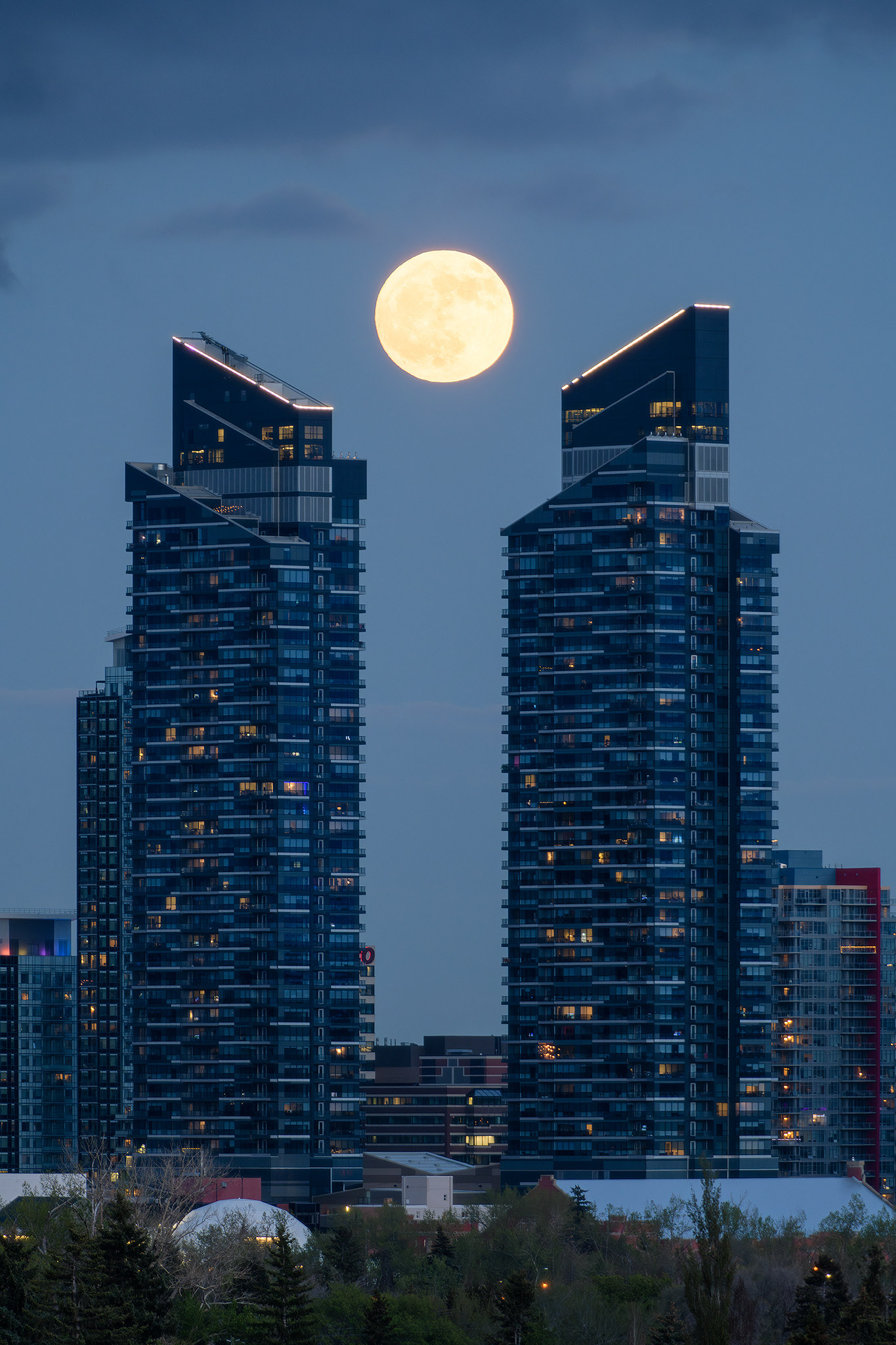 A photo of the Moon rising between the West Village Towers during Civil Twilight, from West Hillhurst, Calgary, AB - May 22nd