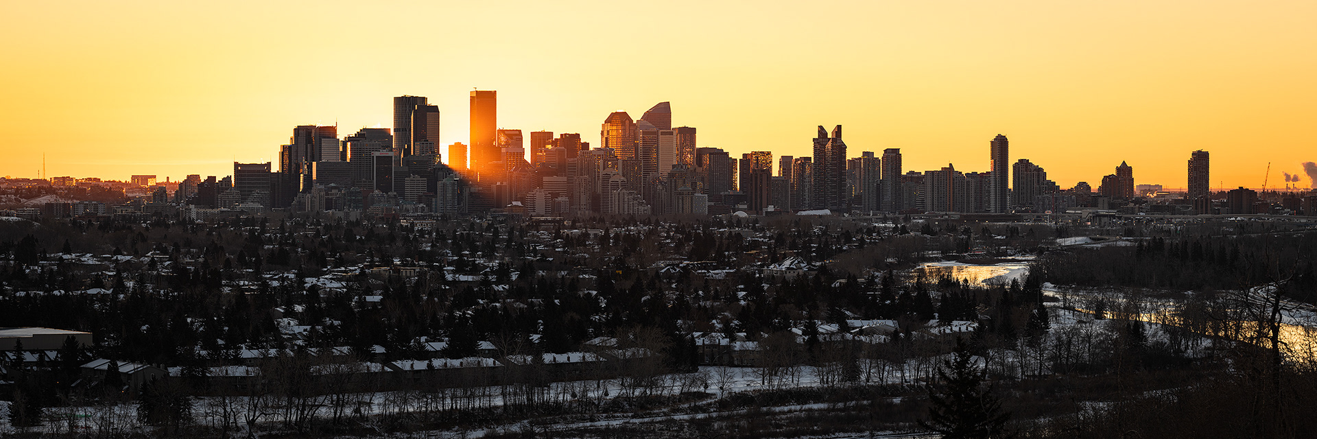 3x1 Sunrise Panoramic Cityscape (6 shot) of the downtown skyline, and Bow River (sun altitude 0.2 degrees), from Edworthy Park, Calgary, AB