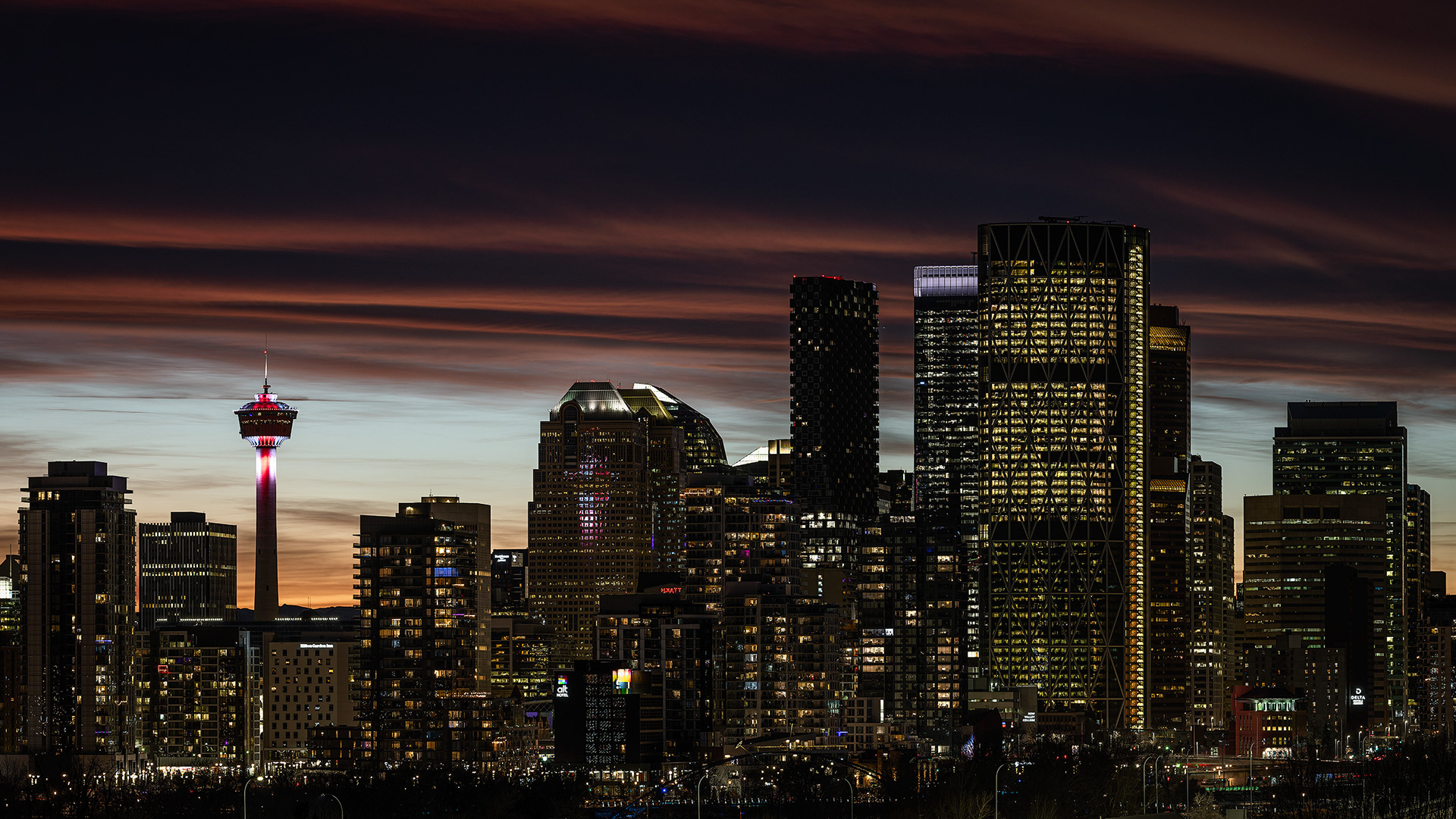 16x9 Panoramic Cityscape (3 shot) of a portion of the downtown skyline [post sunset, Nautical Twilight (sun altitude -7.4 degrees)] from Tom Campbell's Hill Natural Park, Calgary, AB