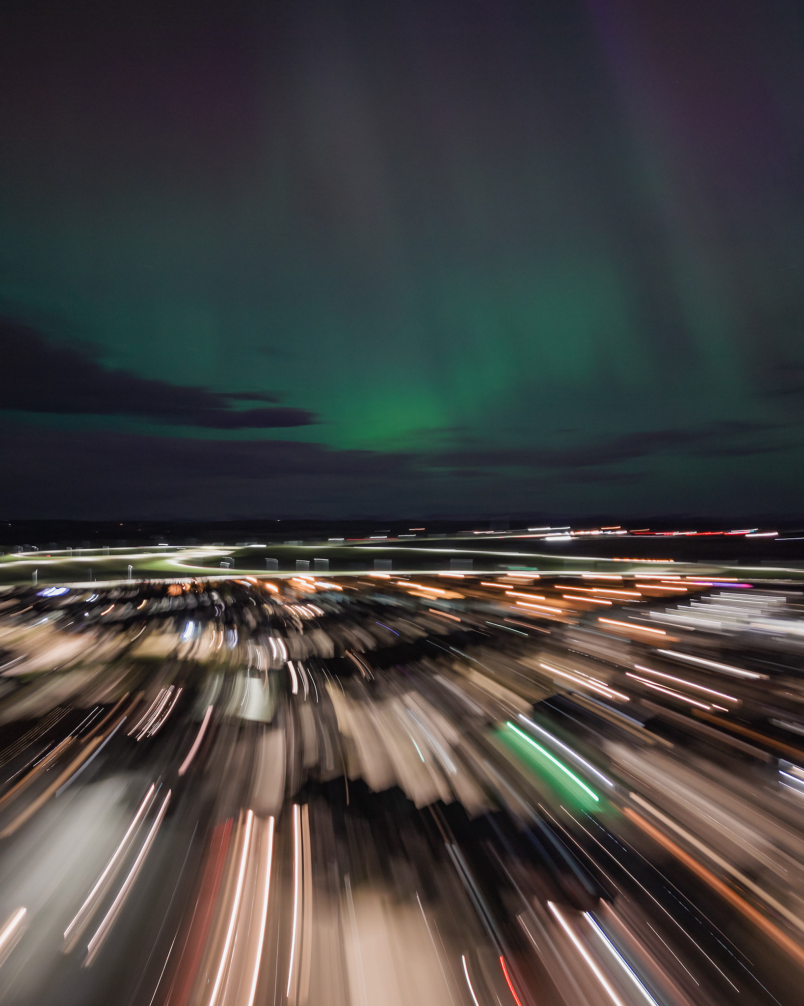 Photo of an Aurora occurrence, with motion blurred neighborhood city lights in the foreground, from Bridlewood, Calgary, AB - May 11th