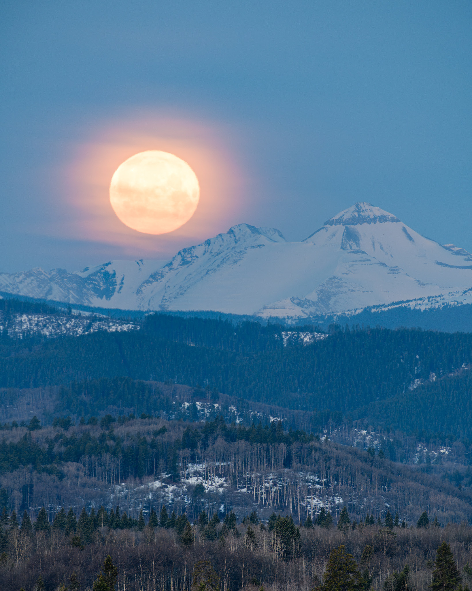 A photo of the Moon setting beyond the Rocky Mountains during Civil Twilight, from near Priddis, Foothills County, AB - April 24th