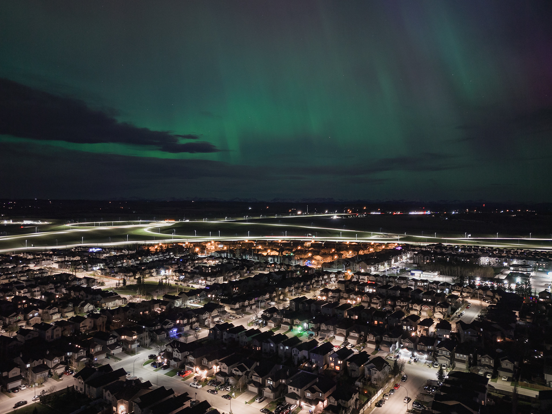 Photo of an Aurora occurrence, with neighborhood city lights in the foreground, from Bridlewood, Calgary, AB - May 11th