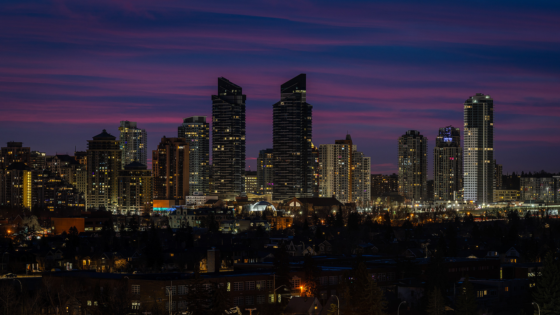 16x9 Panoramic Cityscape (4 shot) of a portion of the downtown skyline [pre sunrise, Nautical Twilight (sun altitude -8 degrees)] from West Hillhurst off-leash area, Calgary, AB