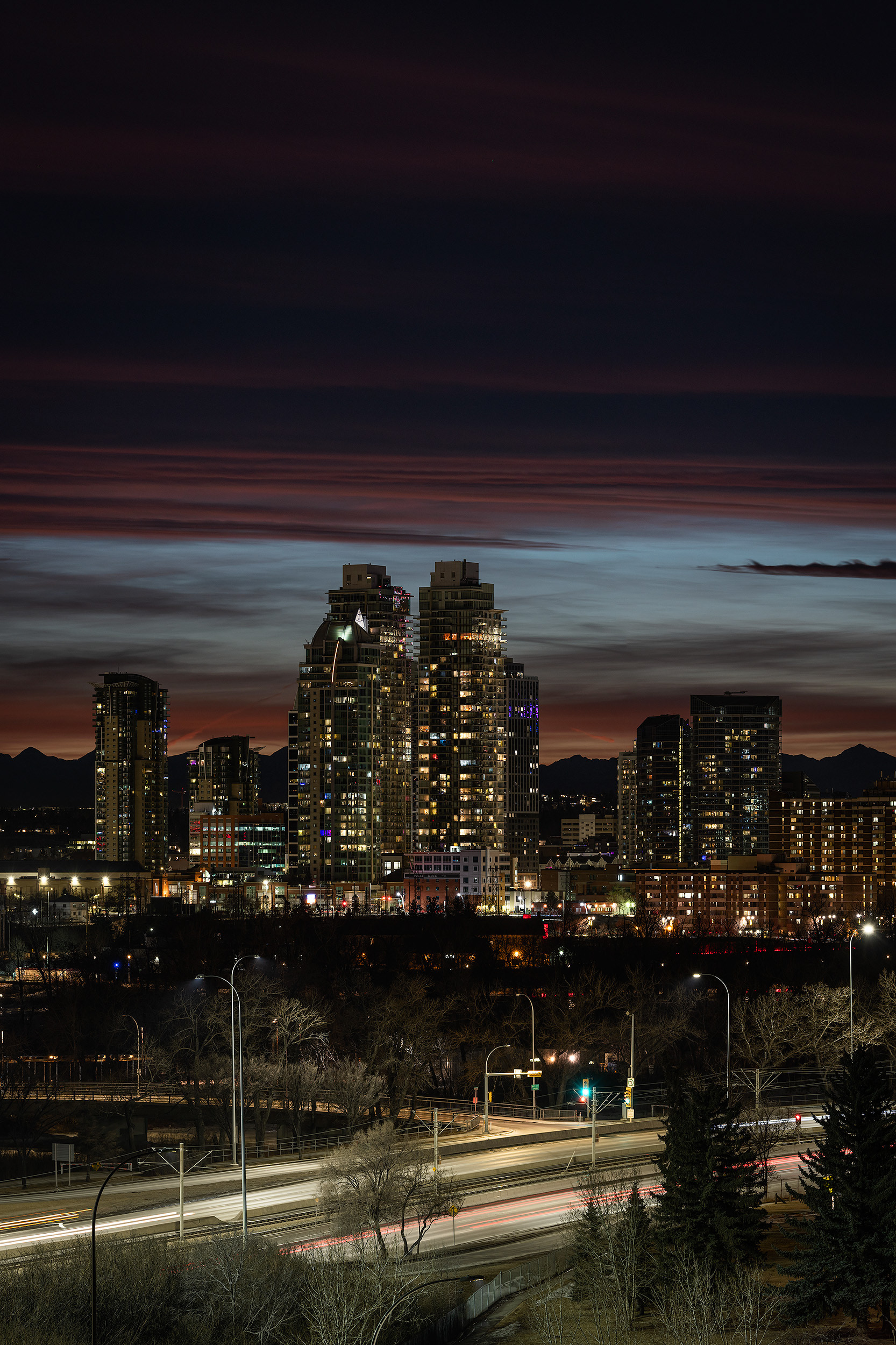 Cityscape, partial of the downtown skyline [post sunset, Nautical Twilight (sun altitude -10 degrees)] from Tom Campbell's Hill Natural Park, Calgary, AB