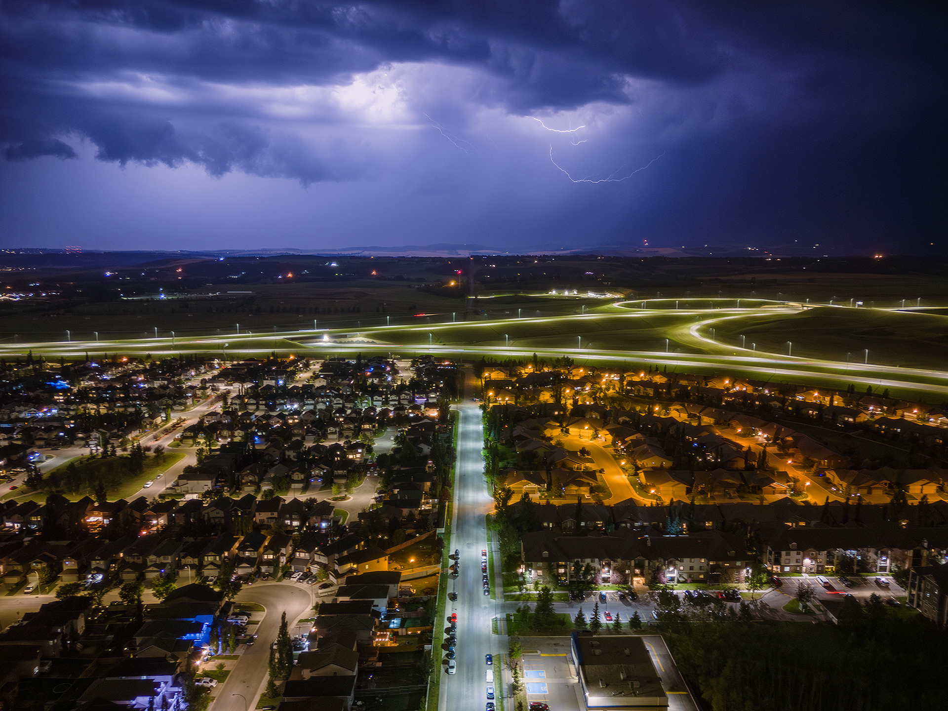 Night time aerial photo, with northbound storm approaching, from over the neighborhood of Bridlewood, Calgary, AB - August 23rd
