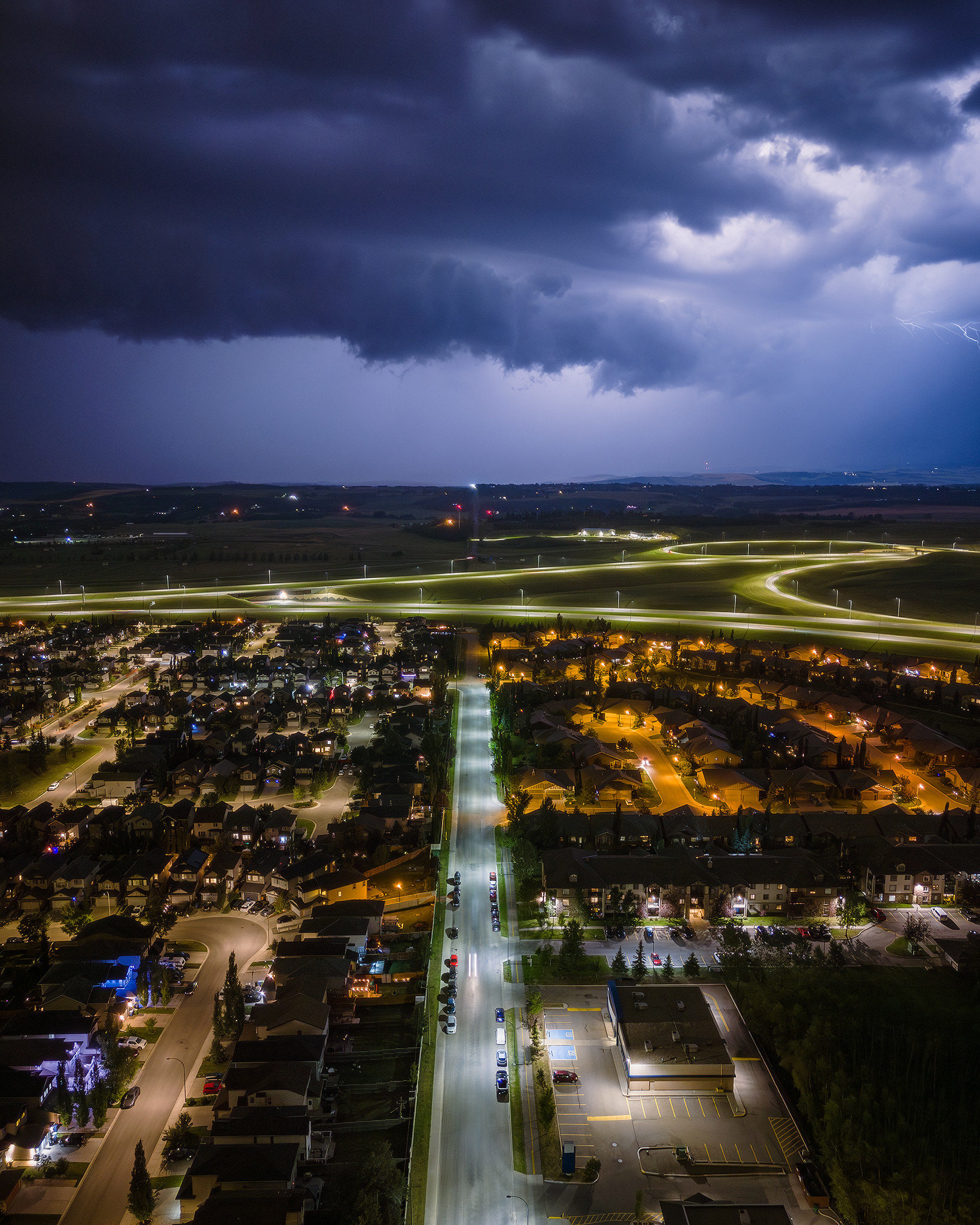 Night time aerial photo, with northbound storm approaching, from over the neighborhood of Bridlewood, Calgary, AB - August 23rd