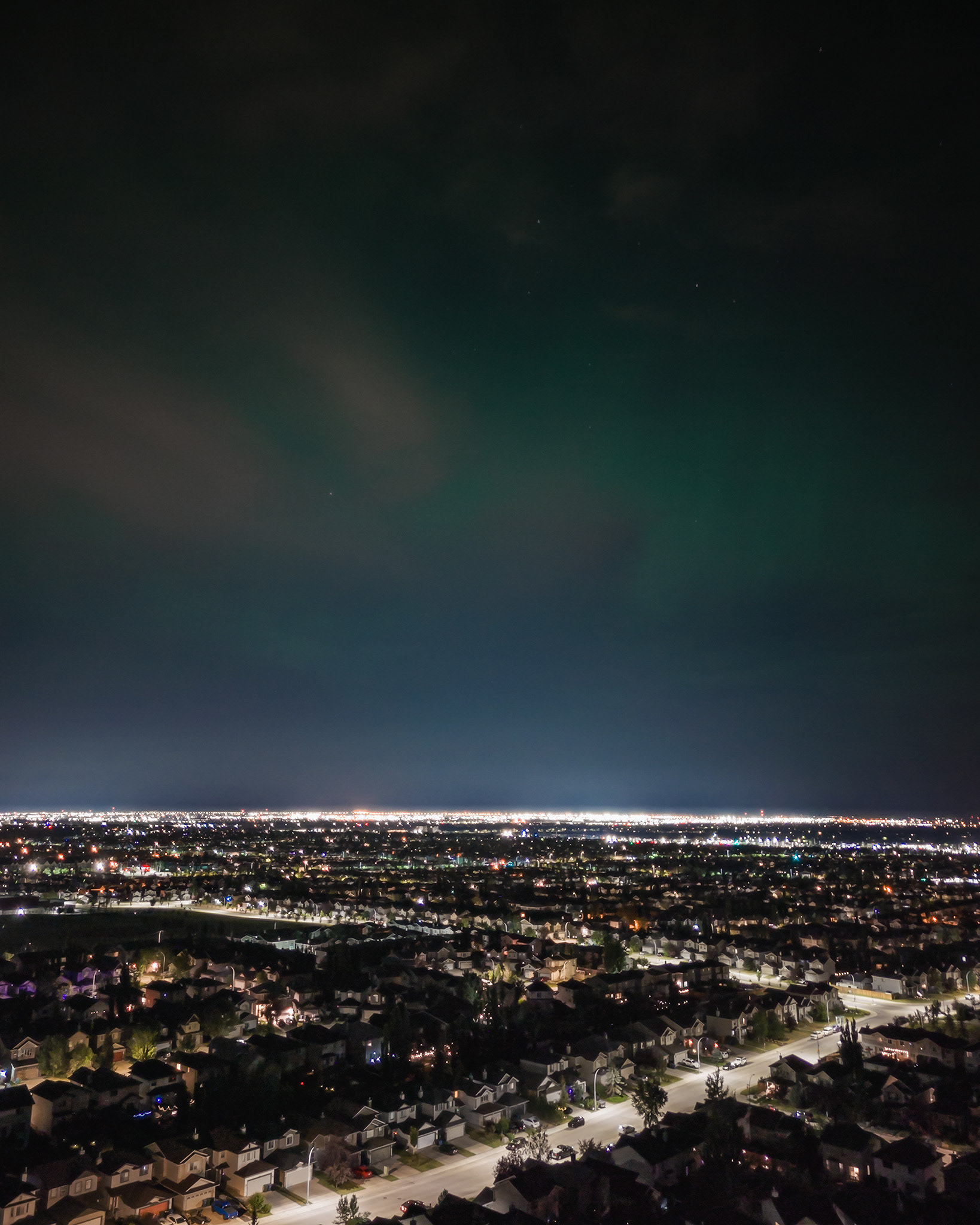Night time aerial photo, with a touch of Aurora present, from over the neighborhood of Bridlewood, Calgary, AB - August 11th