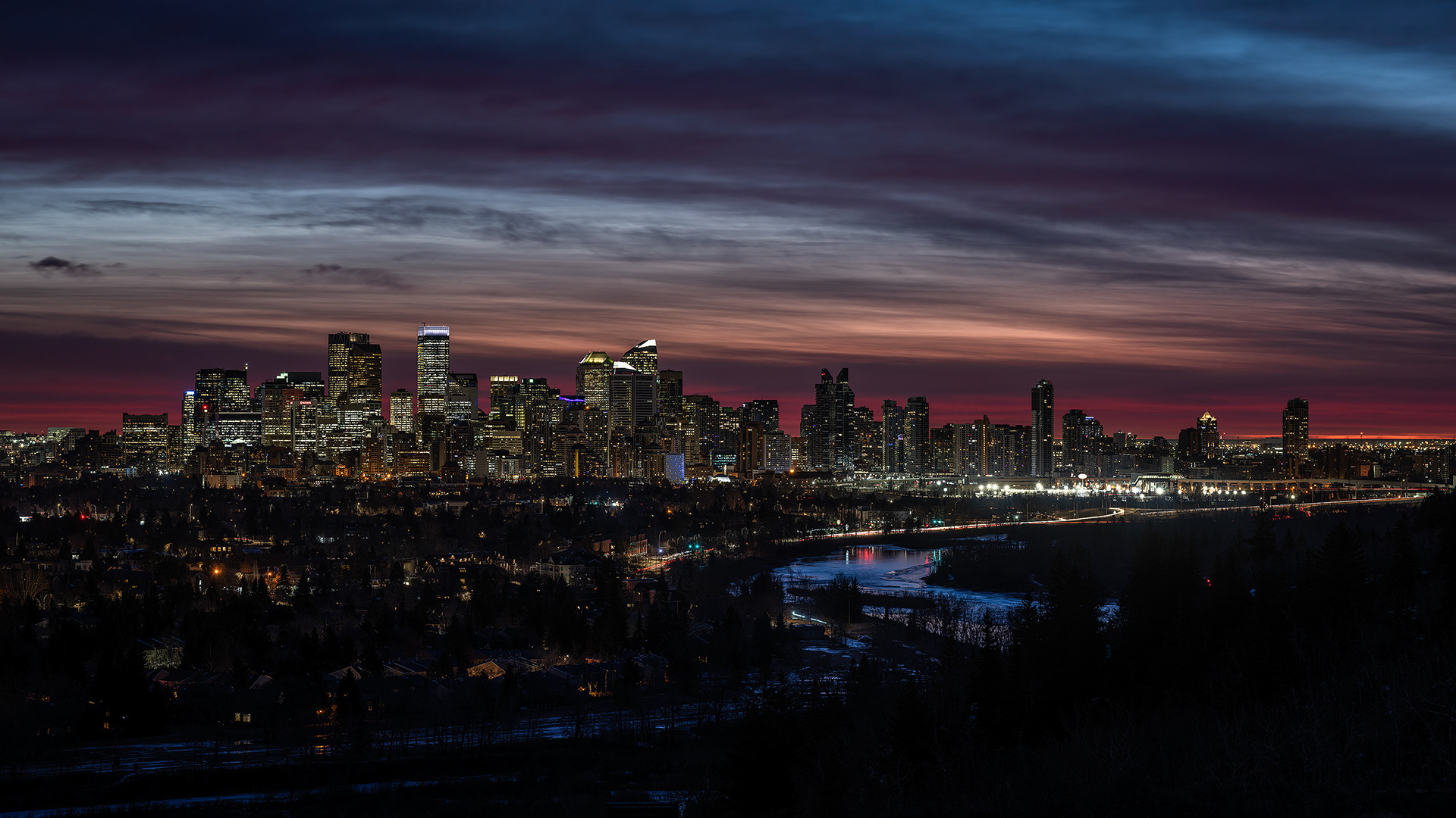 16x9 Panoramic Cityscape (16 shot, 2 row) of the downtown skyline [pre sunrise, Nautical Twilight (sun altitude -8.3 degrees)] from Edworthy Park, Calgary, AB