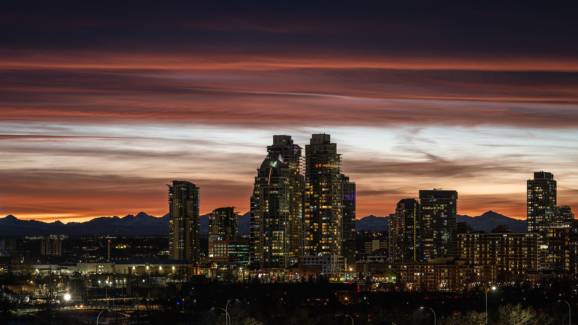 16x9 Panoramic Cityscape (3 shot) of a portion of the downtown skyline [post sunset, Nautical Twilight (sun altitude -7.4 degrees)] from Tom Campbell's Hill Natural Park, Calgary, AB