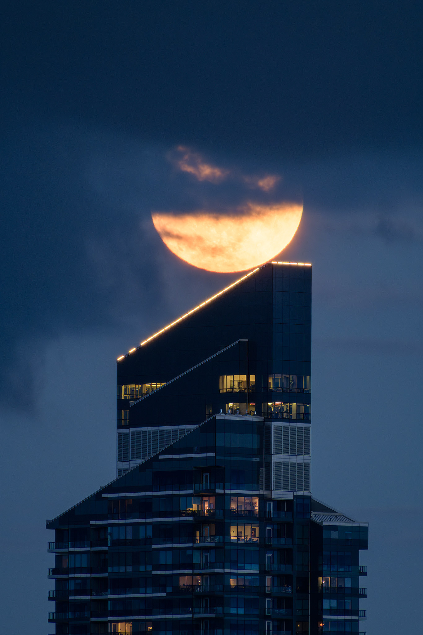 A photo of the Moon rising over the West tower, of the West Village Towers, during Civil Twilight, from West Hillhurst, Calgary, AB - May 22nd