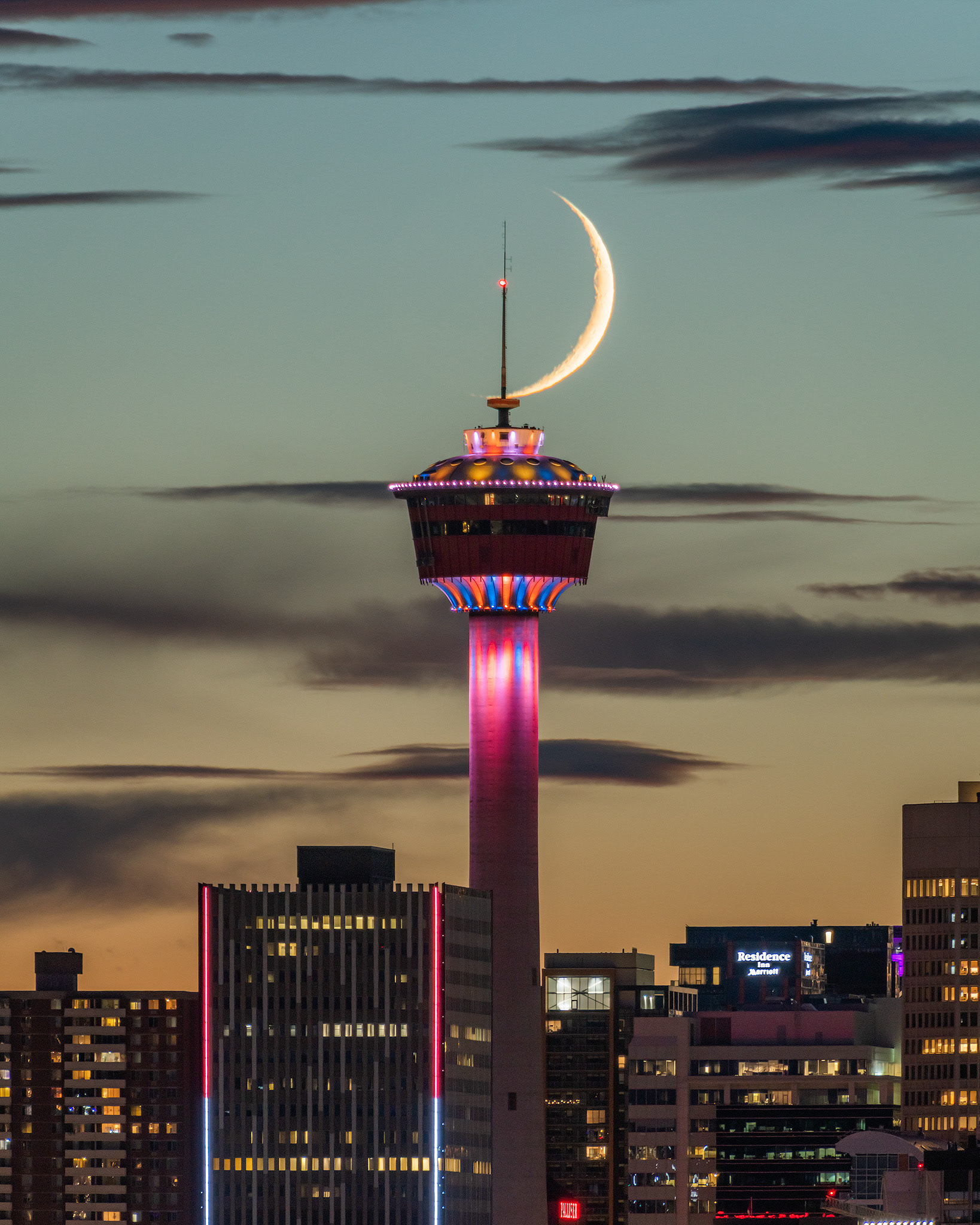 Setting Waxing Crescent Moon (8%) aligned with the Calgary Tower, from Memorial Drive E roadside, Calgary, AB