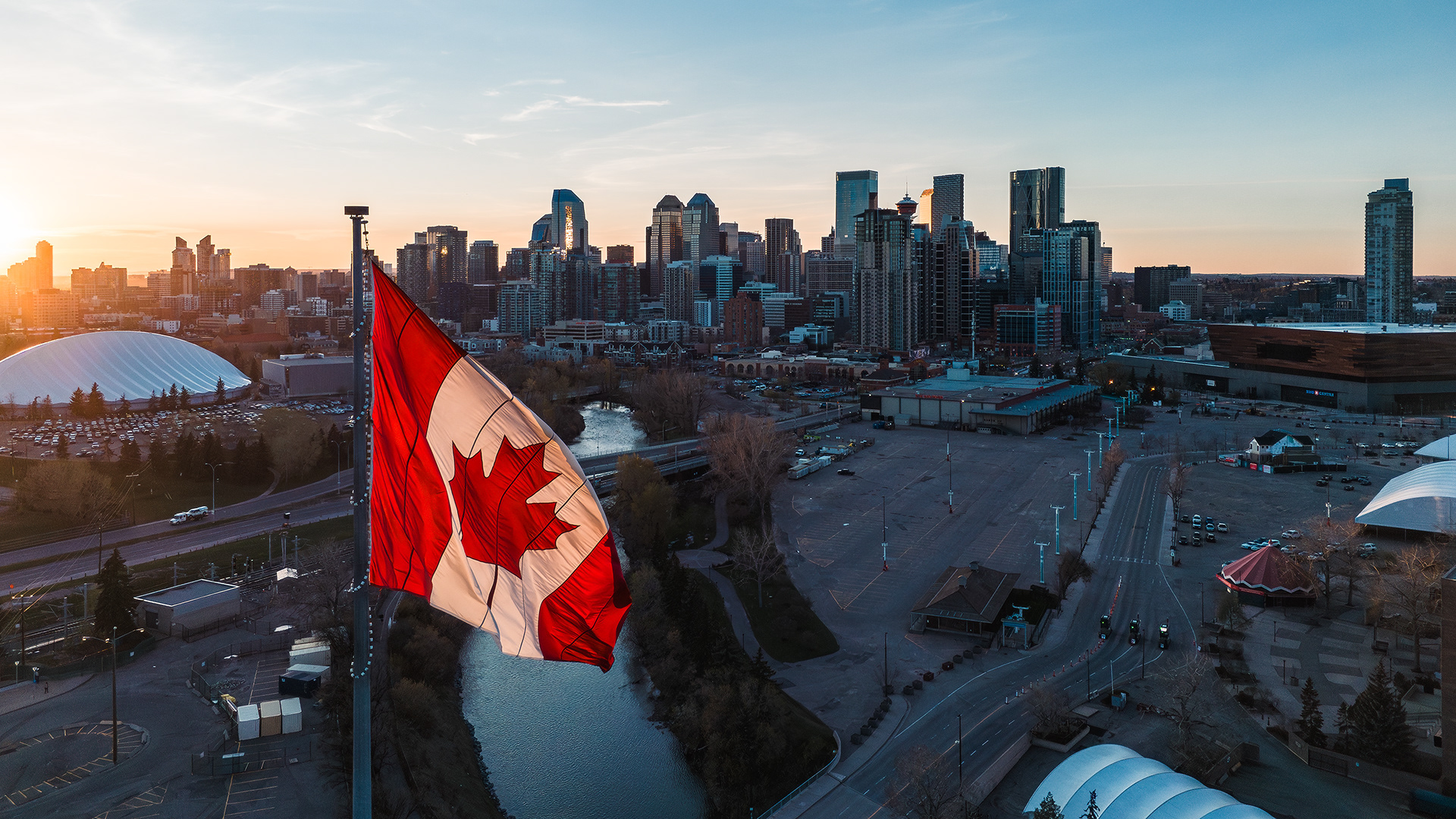 Photo of a Canada flag, with the Downtown Calgary skyline in the background, from near the Calgary Stampede, Calgary, AB - May 9th