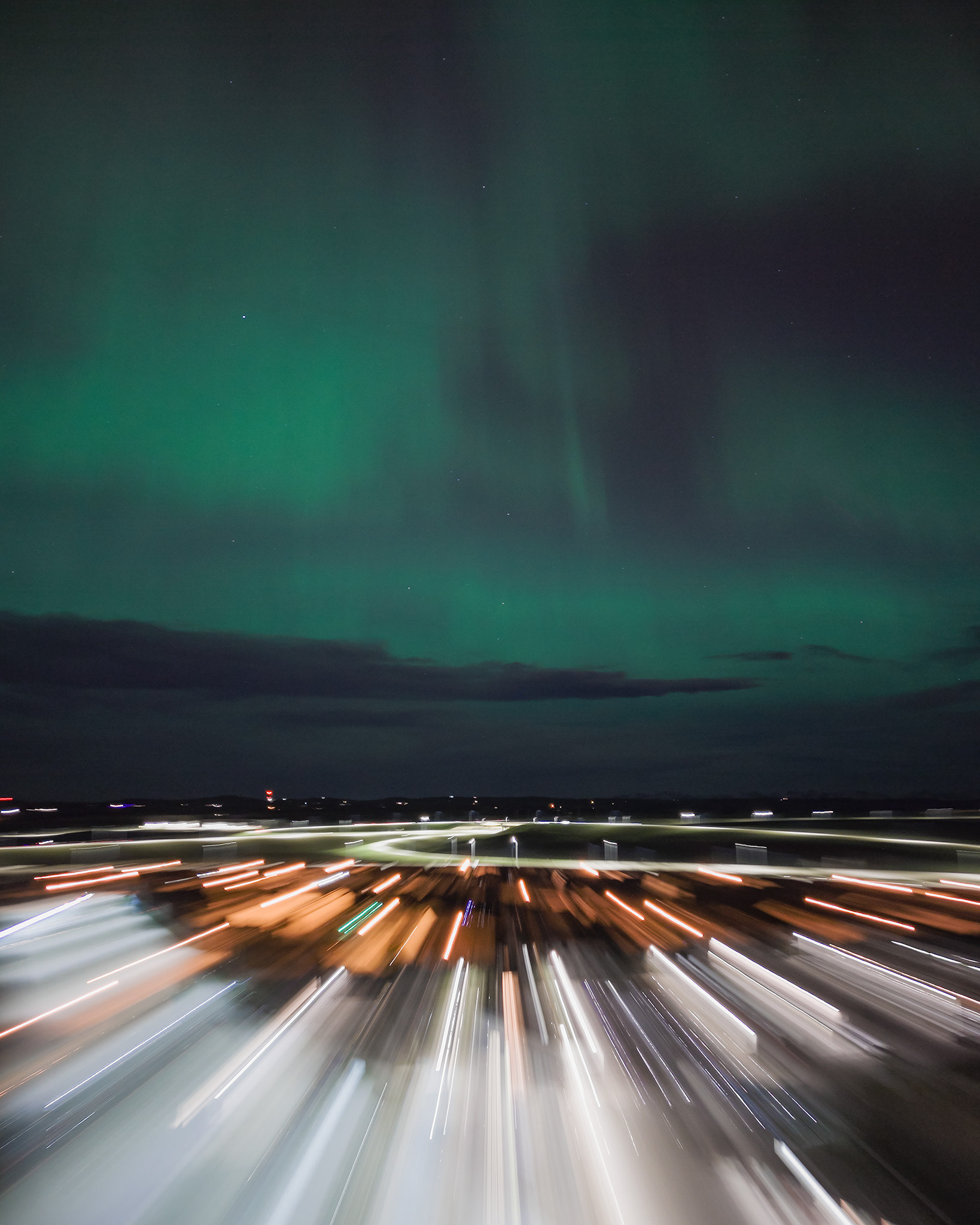 Photo of an Aurora occurrence, with motion blurred neighborhood city lights in the foreground, from Bridlewood, Calgary, AB - May 11th