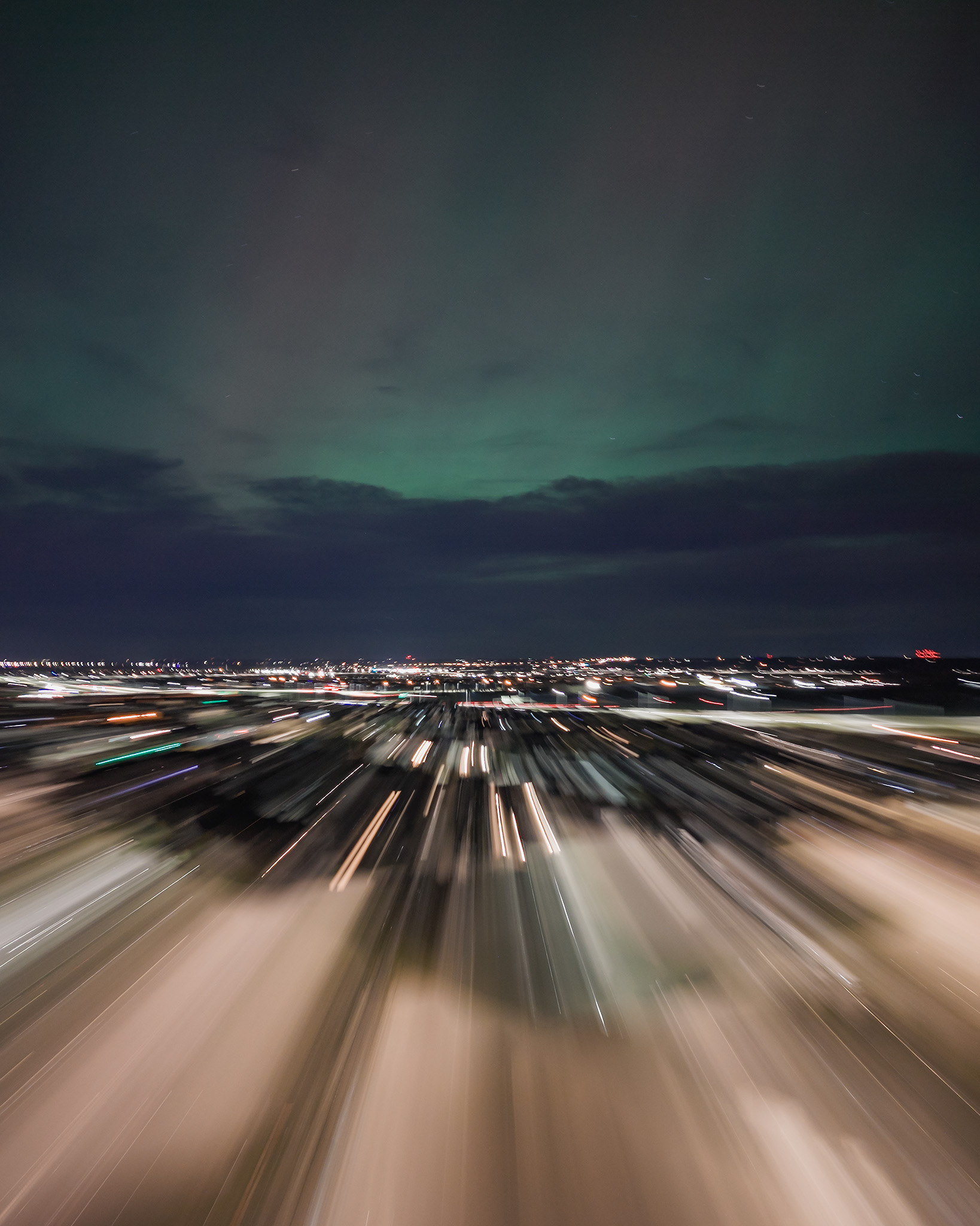 Photo of an Aurora occurrence, with motion blurred neighborhood city lights in the foreground, from Bridlewood, Calgary, AB - May 11th