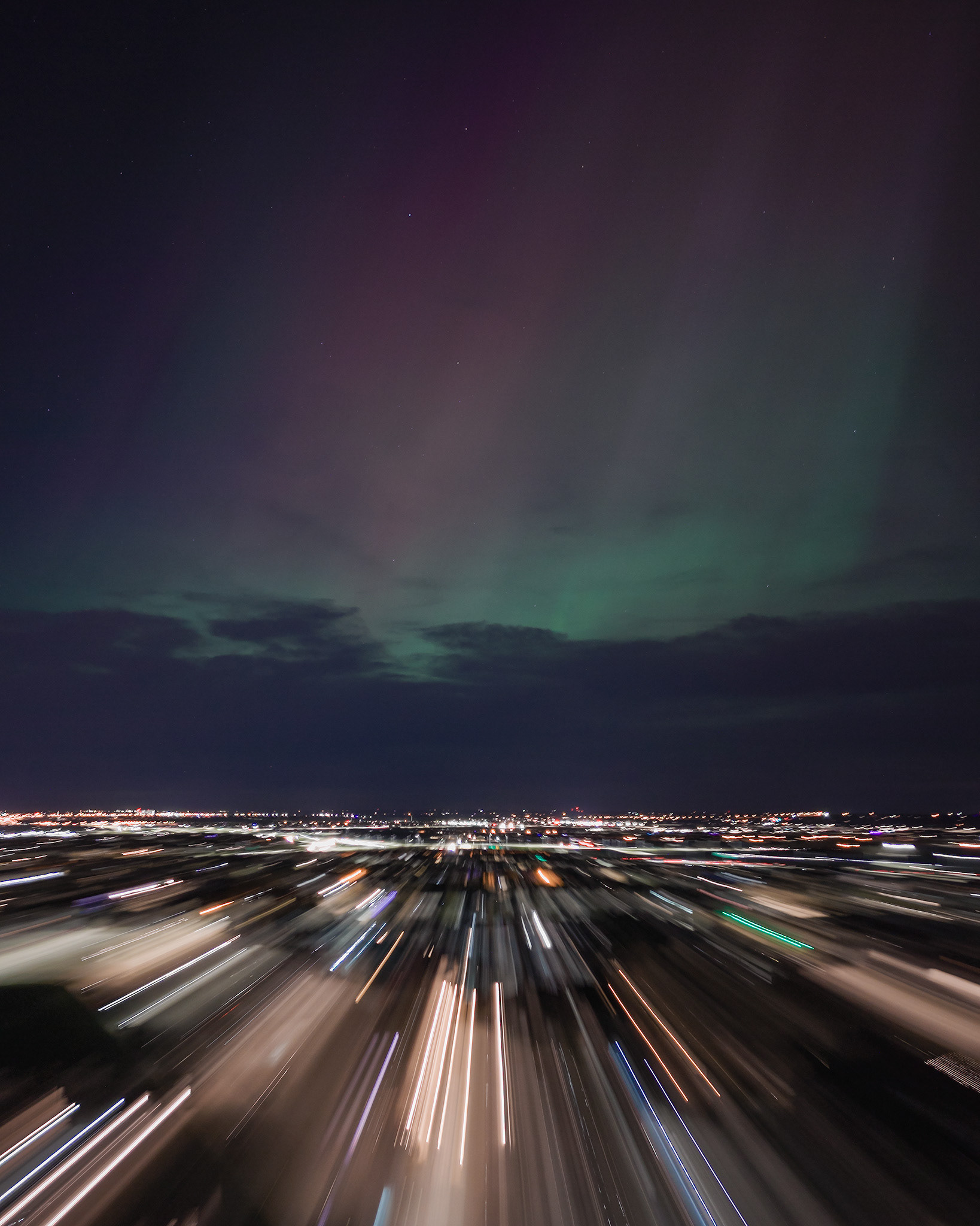 Photo of an Aurora occurrence, with motion blurred neighborhood city lights in the foreground, from Bridlewood, Calgary, AB - May 11th